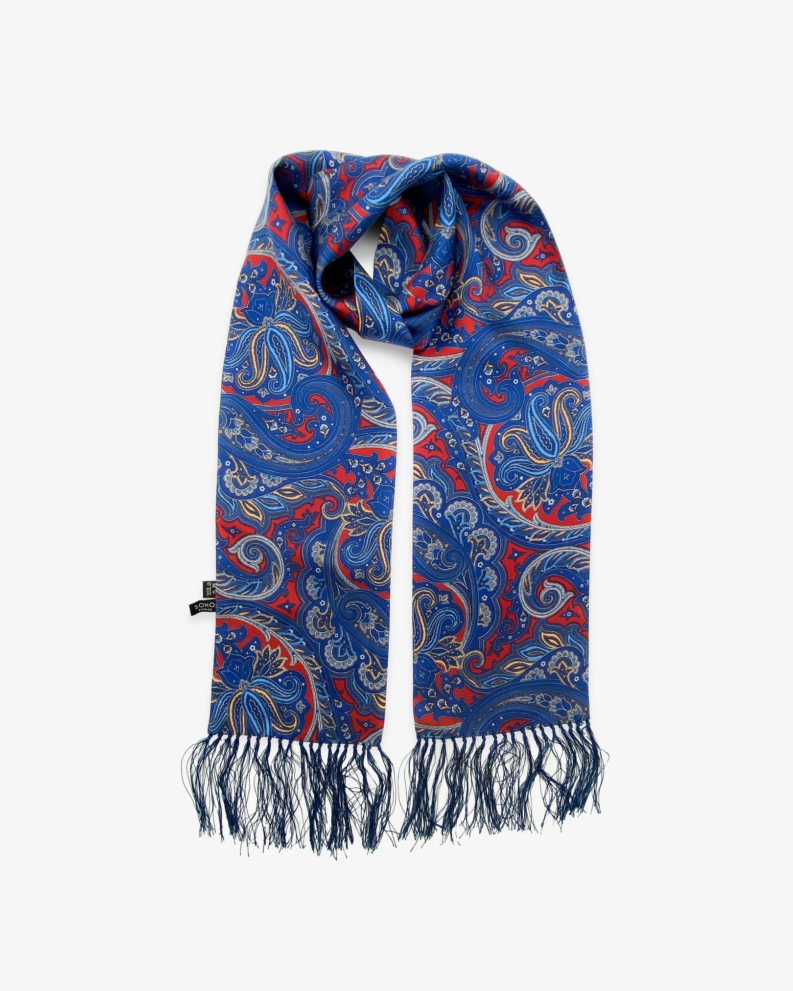 The Oxford pure silk aviator paisley scarf looped in middle with both ends parallel showing the navy-blue paisley patterns on a deep-red ground with matching 3-inch fringe.