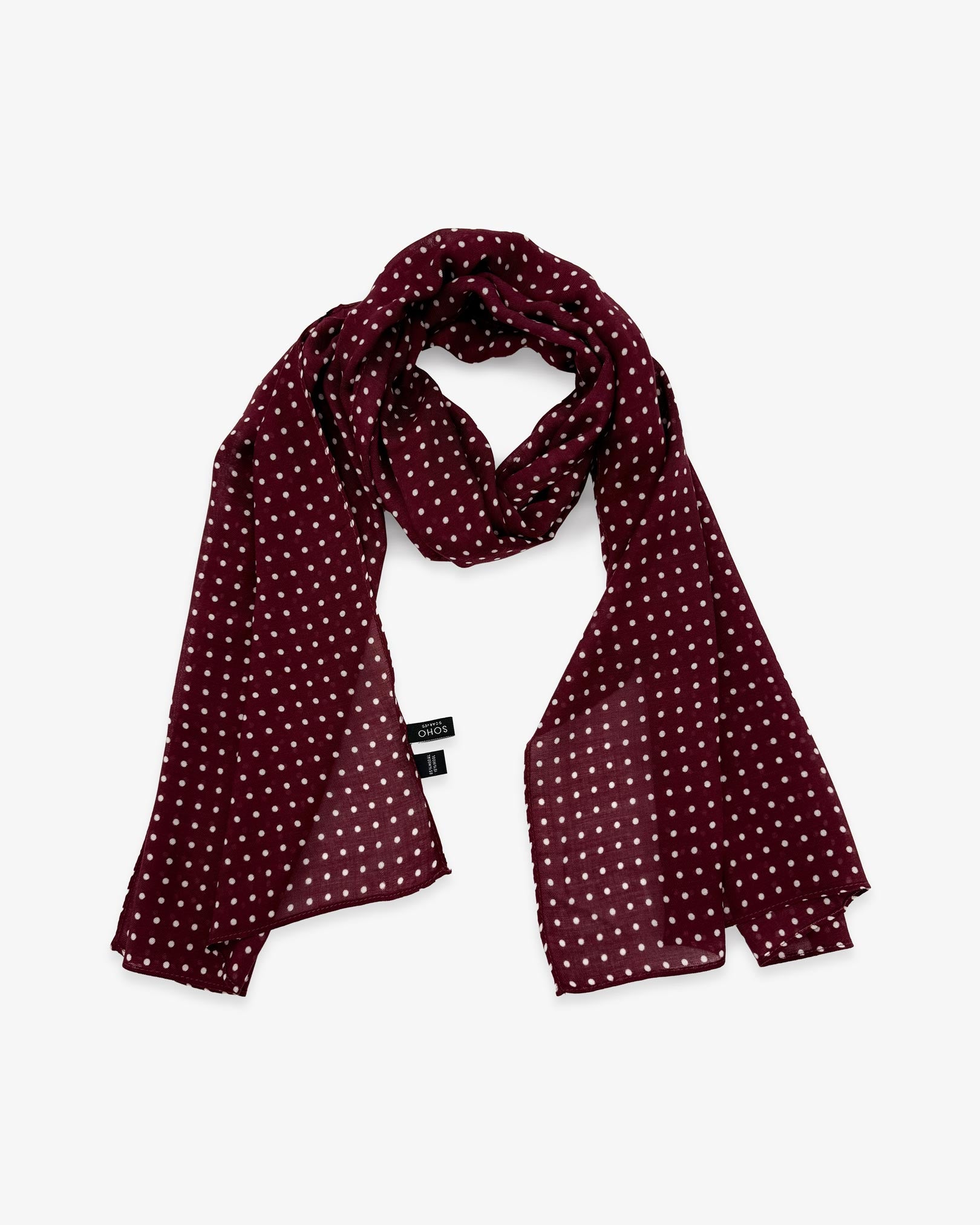 The Sapporo wide scarf unravelled and looped in the middle, demonstrating the longer scarf length and polka dot patterns.