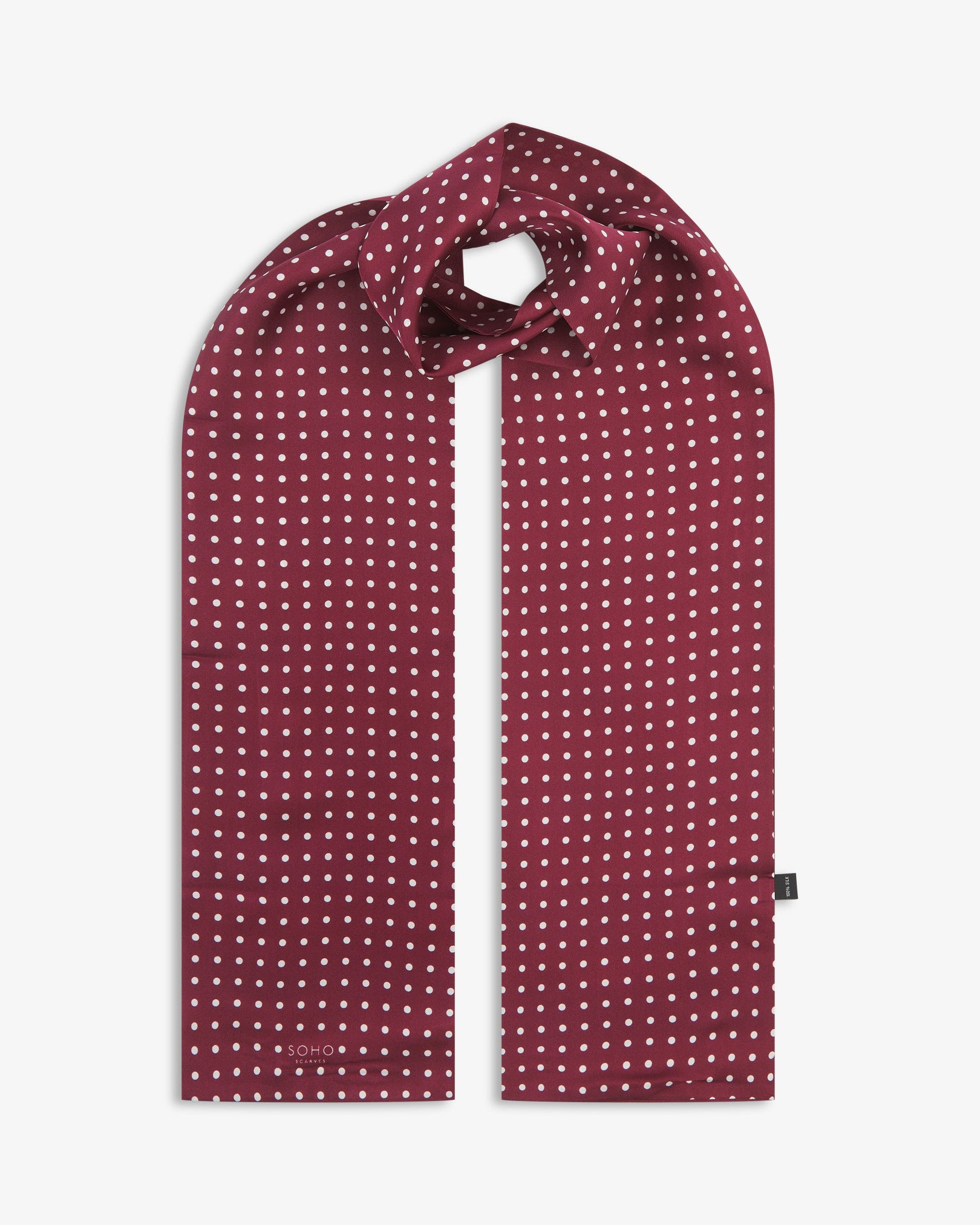 The Sapporo pure silk scarf looped in middle with both ends parallel showing the polka dot design in deep maroon with white dots.