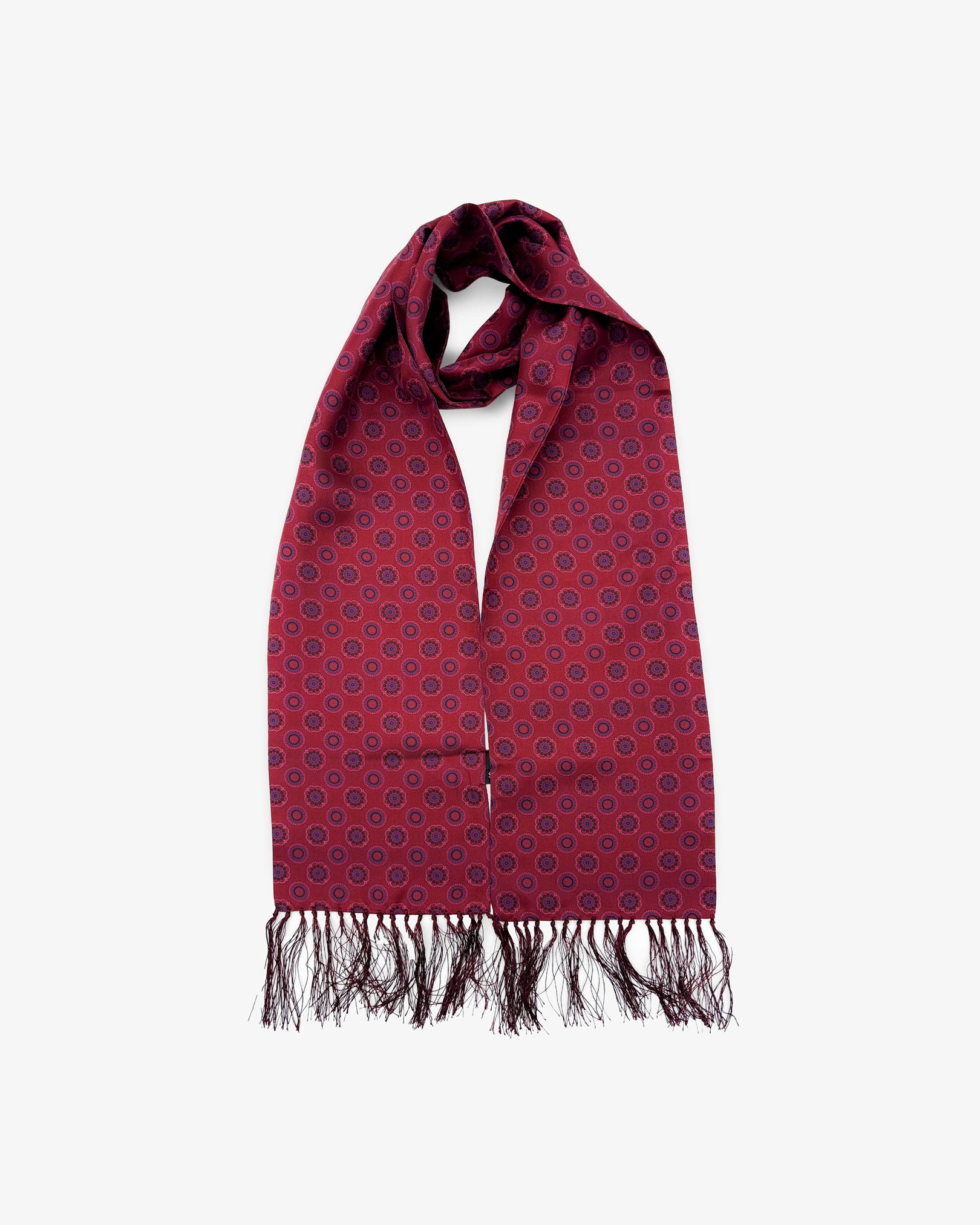 The Seattle pure silk aviator scarf looped in middle with both ends parallel showing the dark burgundy red with circle pattern and SOHO branding label.