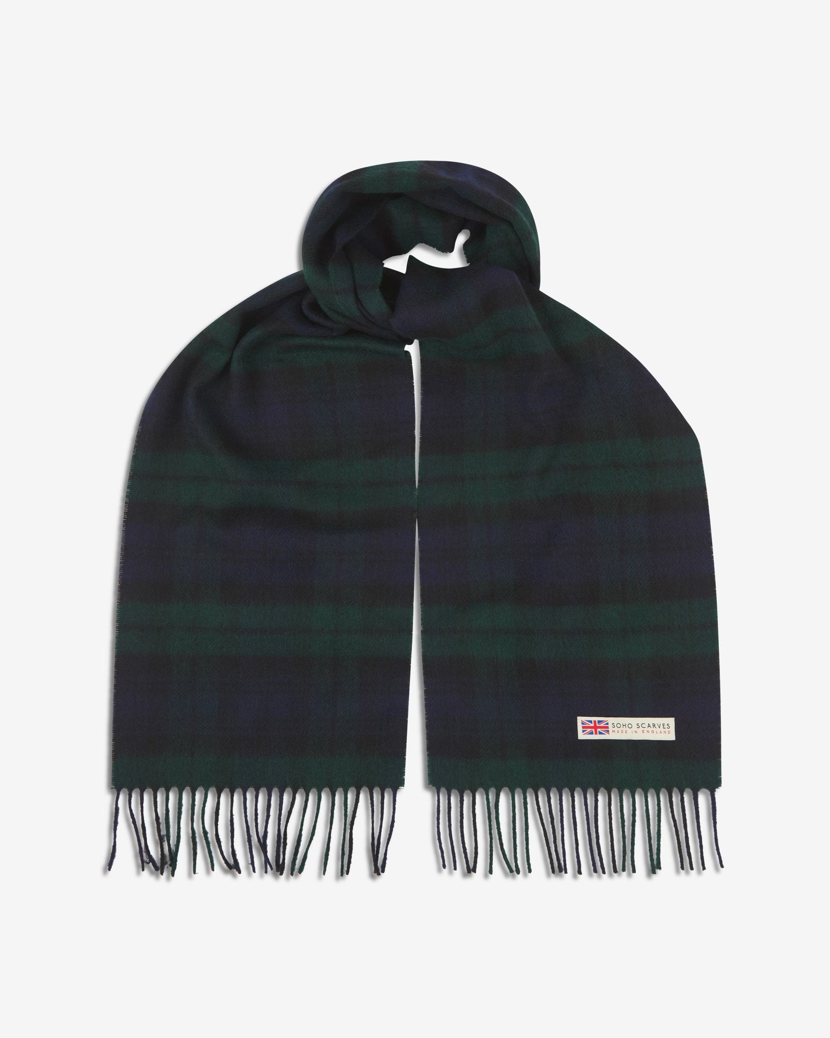 The 'Shetland' tartan in green scarf, looped in middle with both ends parallel showing the dark greens and blues, fringing and SOHO Scarves logo with Union Jack motif.