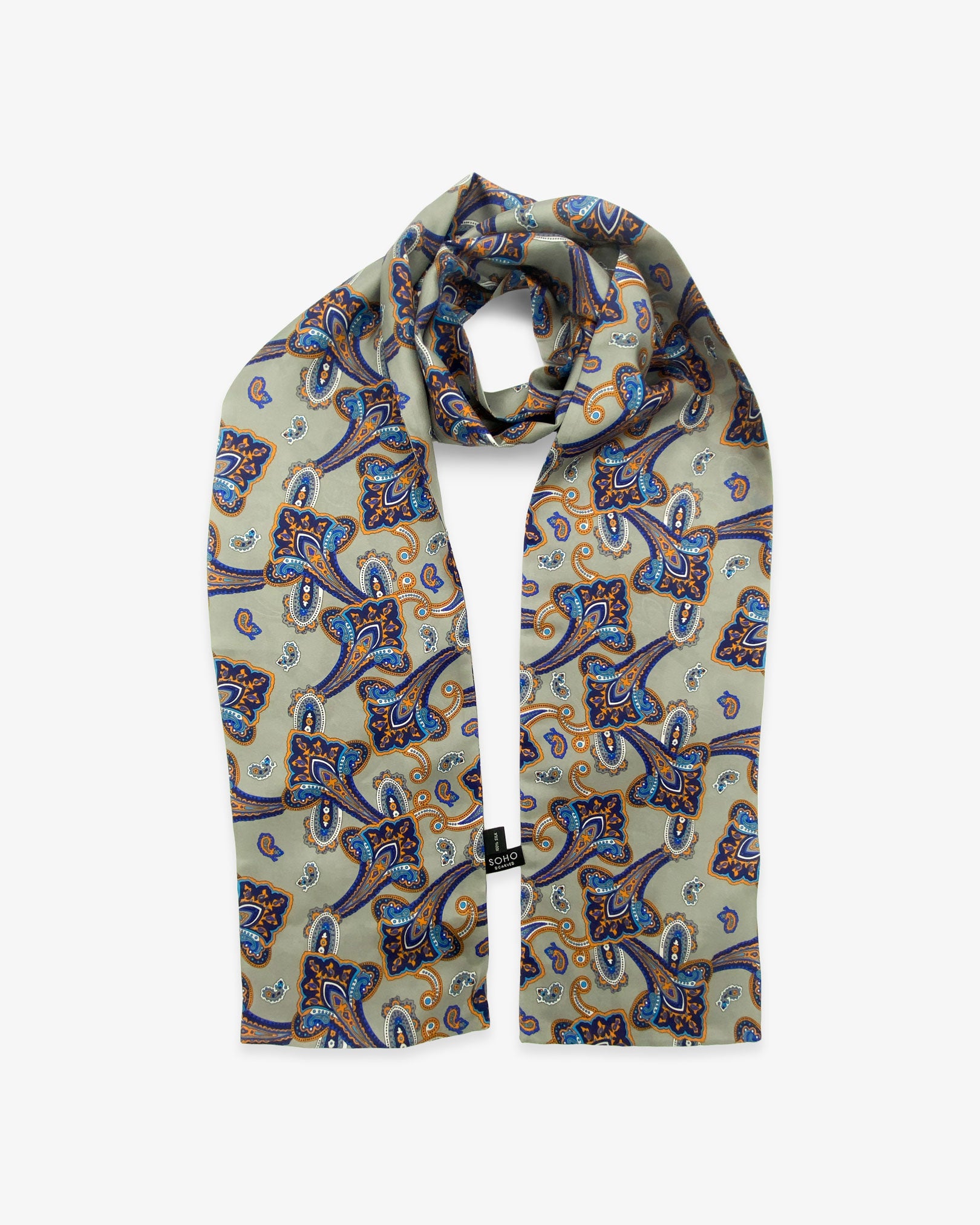 The Tremblant polyester paisley scarf looped in middle with both ends parallel showing the orange and light blue paisley 'trumpets' on a grey-cream ground.