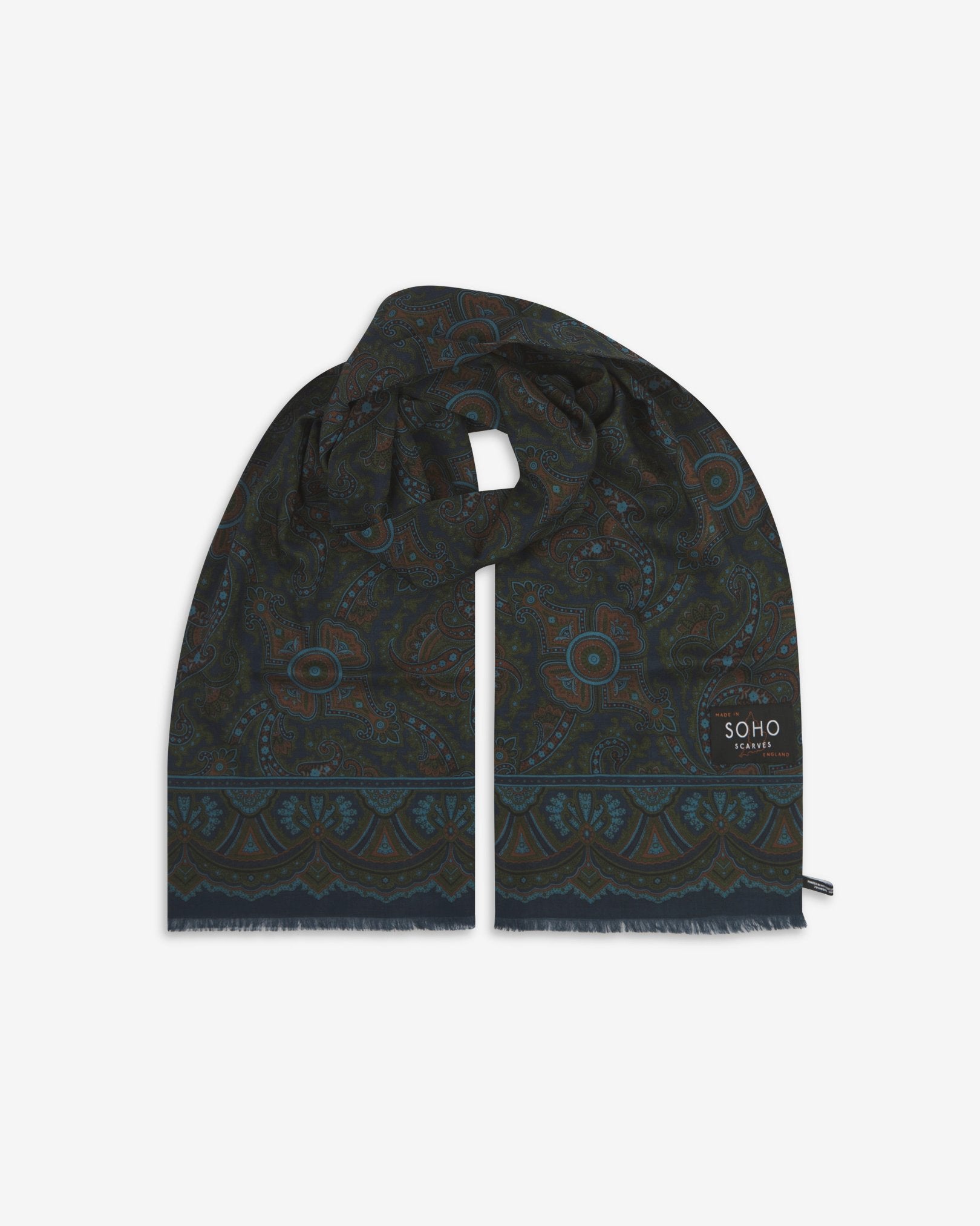 Premium navy blue paisley silk-wool scarf unravelled and looped in the middle, presenting slightly longer and wider scarf dimensions, ornate border, eyelash fringing and 'Soho Scarves' label.