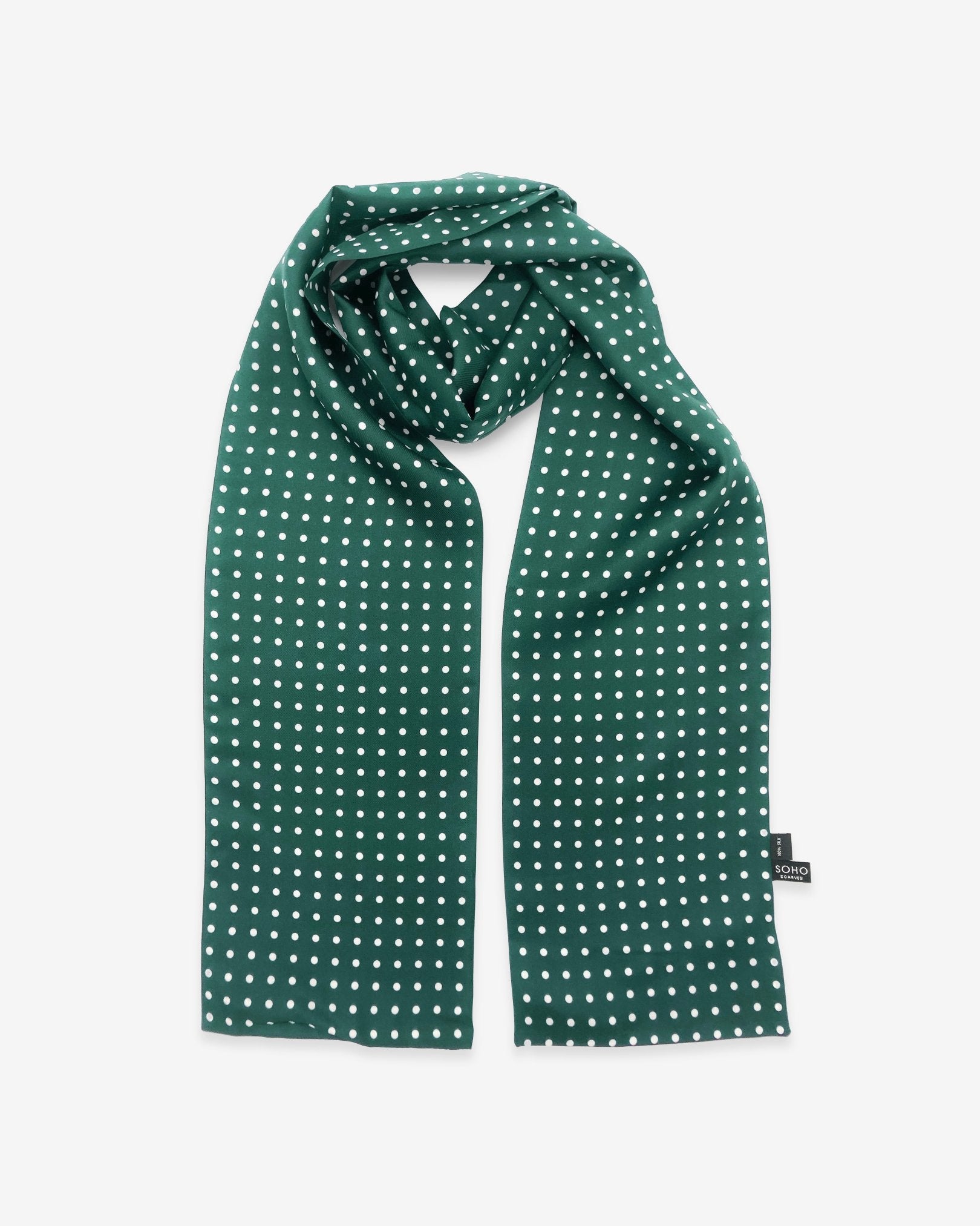 The 'Westminster Rg' racing green silk scarf with white polka-dot patterns.  Looped in middle with both ends parallel showing the the 'Soho Scarves' label on the right edge.