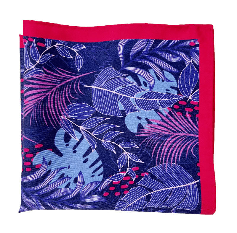 The 'Mersey' silk pocket square from SOHO Scarves folded into a quarter, showing the leaf montage pattern and bright red border.