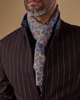 Close-up of 'The Regent' paisley polyester scarf snugly wrapped around model's neck with clear view of light blue coloured fabric with multicoloured paisley patterns.