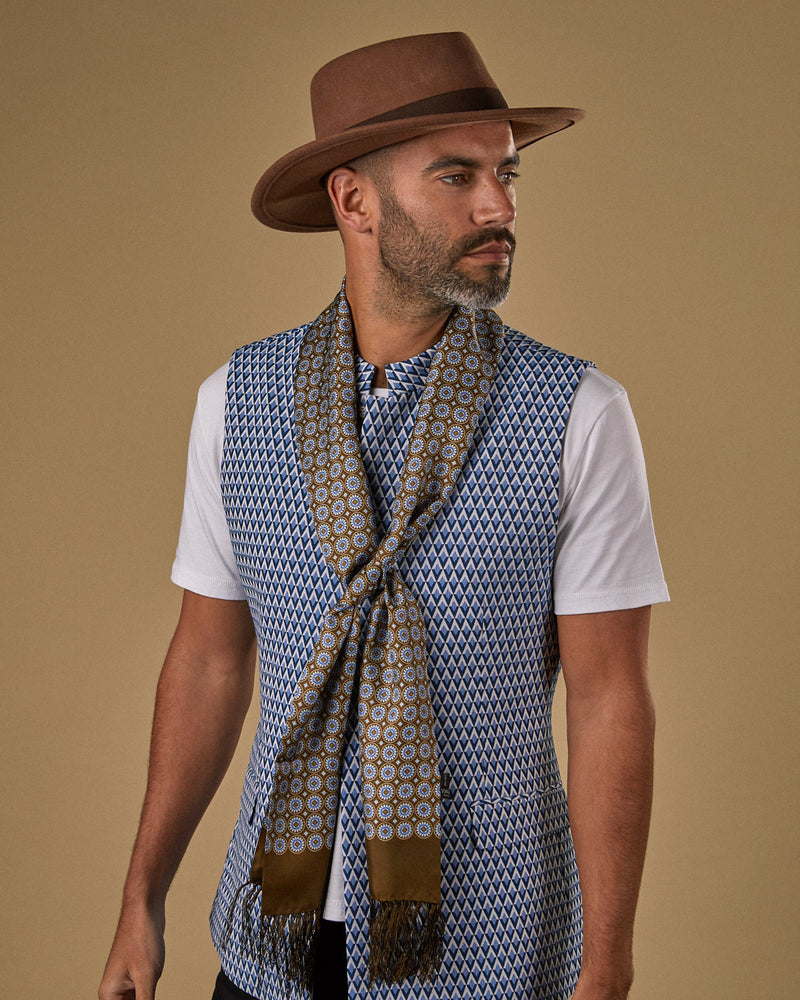 Model wearing brown 'The Bellingham Aviator' with brown 3-inch dark fringe and paired with geometric patterned waistcoat.