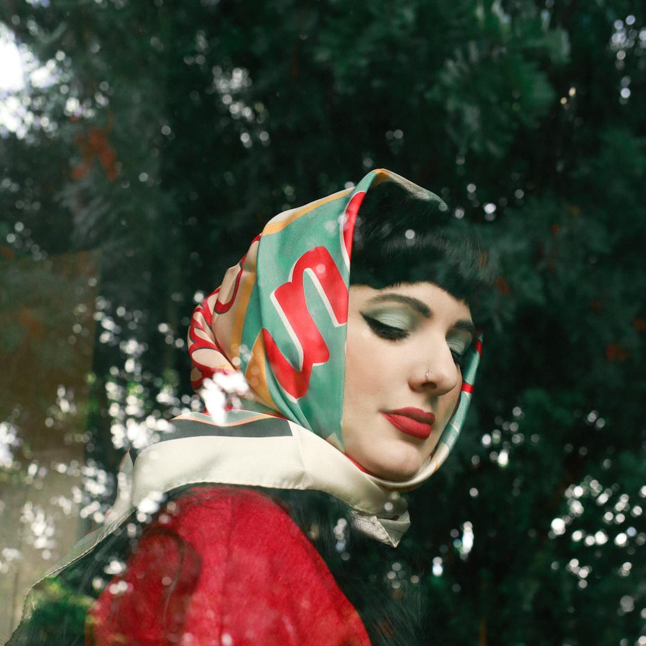 Woman in 1950's attire wearing matching 'Milkshake on Chalk' retro headscarves from SOHO Scarves.