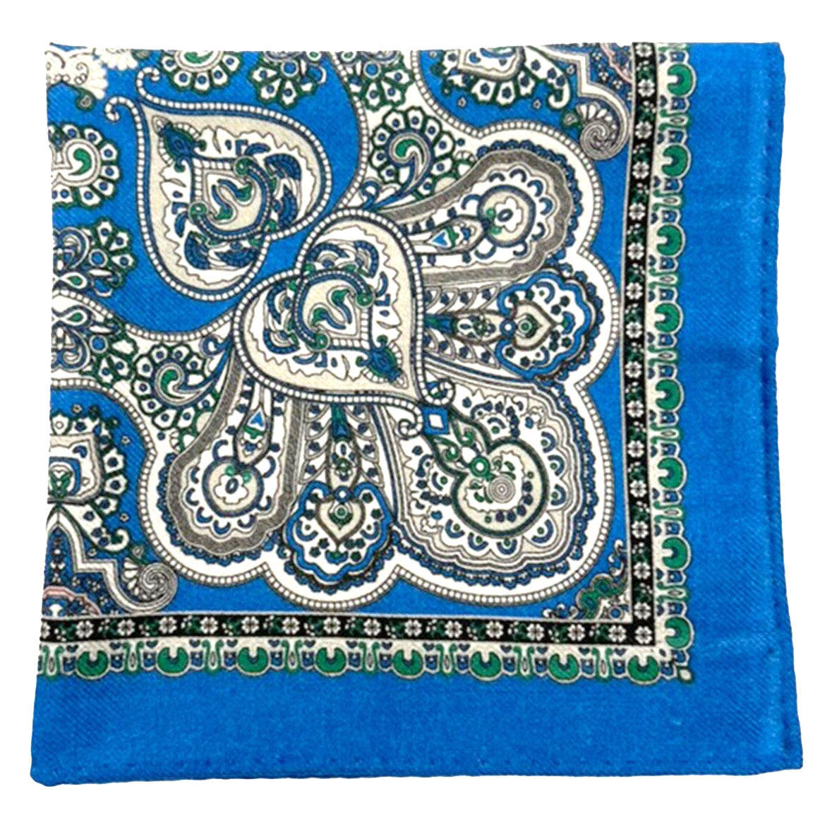 The 'Nomme' wool pocket square from SOHO Scarves folded into a quarter, showing the interlocking paisley patterns framed by a beautifully intricate green border.