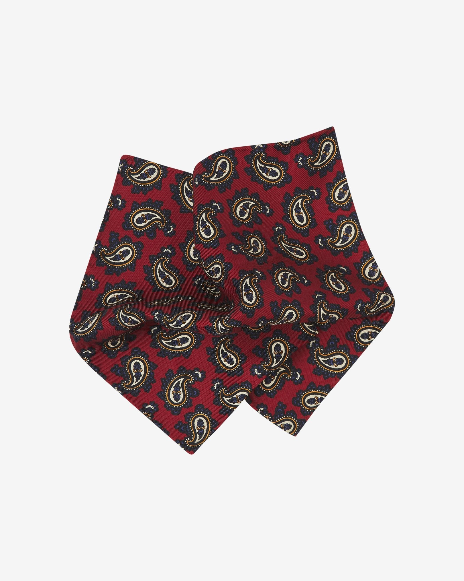 The 'Binham' pocket square pinched and twisted in the middle, showing the classic paisley patterns against a red background.