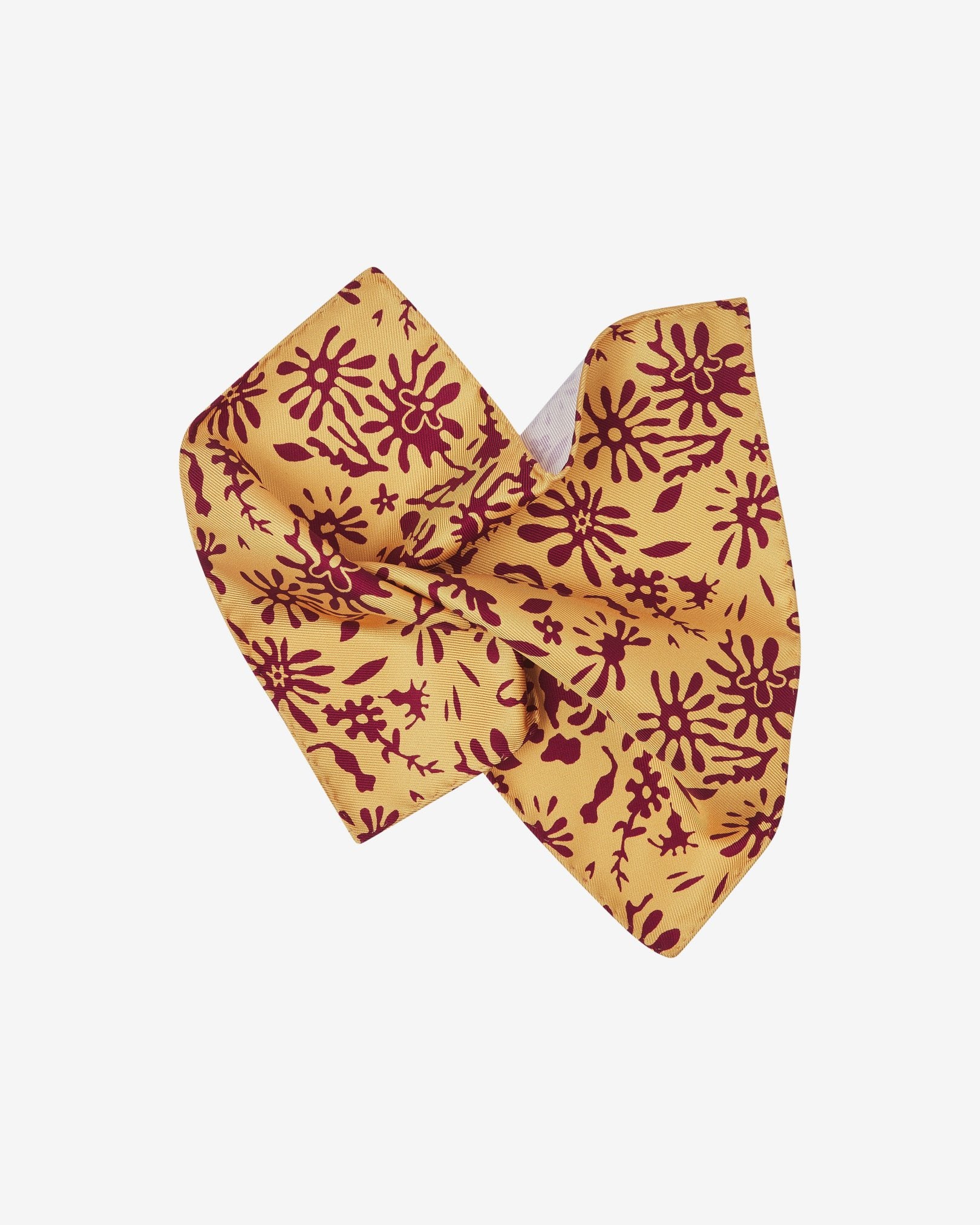 The 'Blenheim' pocket square pinched and twisted in the middle, showing the organic maroon patterns against a bright yellow ground.