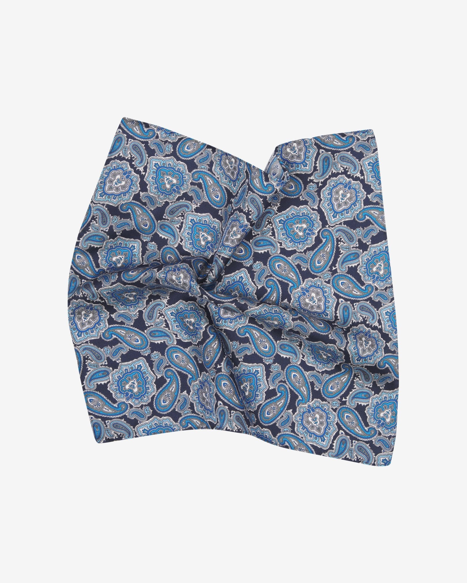 The 'DeZon' silk pocket square pinched and twisted in the middle, presenting a closer view of the blue paisley patterns enhanced with white and grey accents.