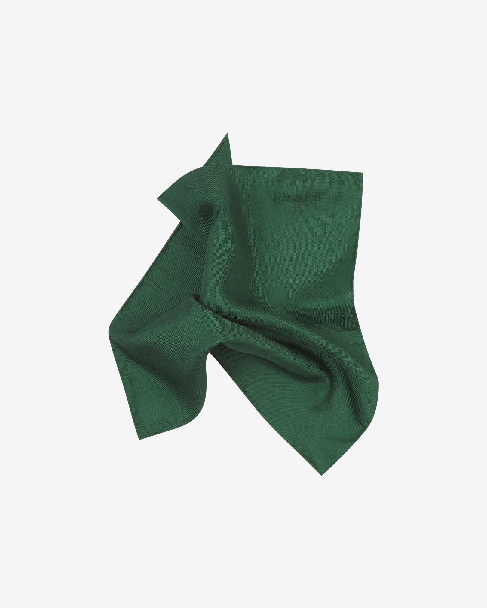 The plain, green silk pocket square pinched and twisted in the middle, presenting the sheen of the fine silk material.