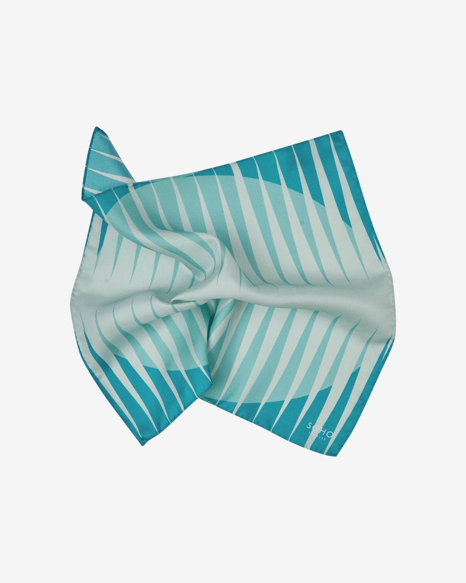 The 'Hamburg' pocket square pinched and twisted in the middle, showing the bauhaus-inspired triangular and circular forms in a cool palette.