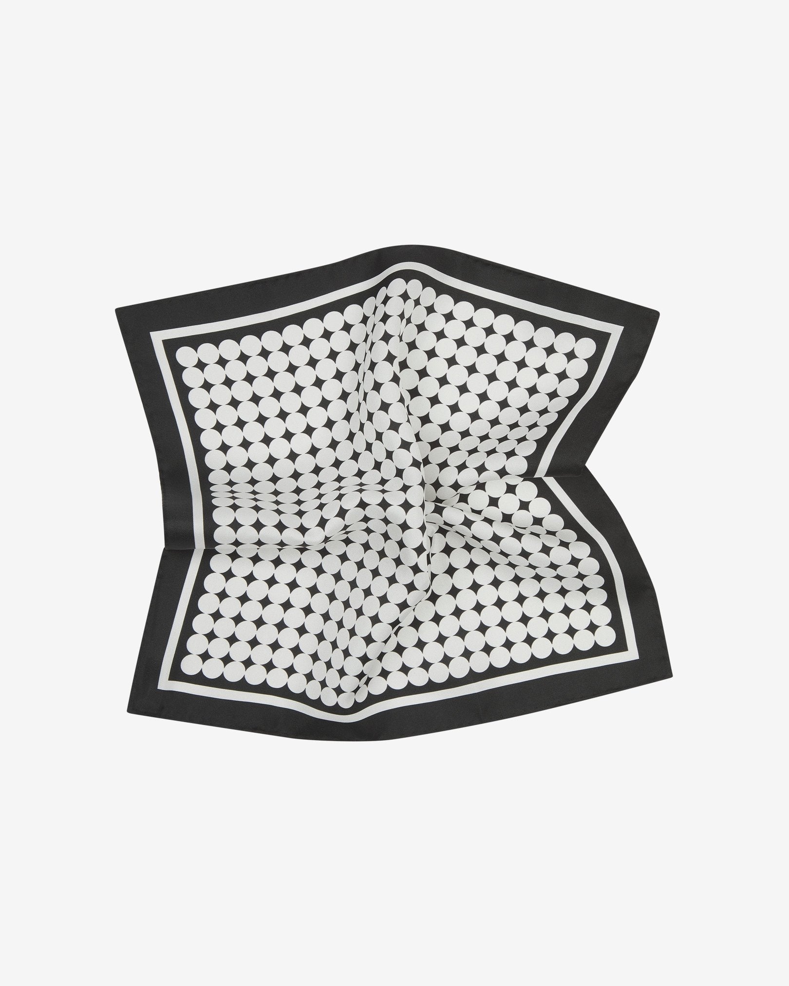 The 'Keaton' silk pocket square pinched and twisted in the middle, showing white circles tightly packed in straight lines on a black background.