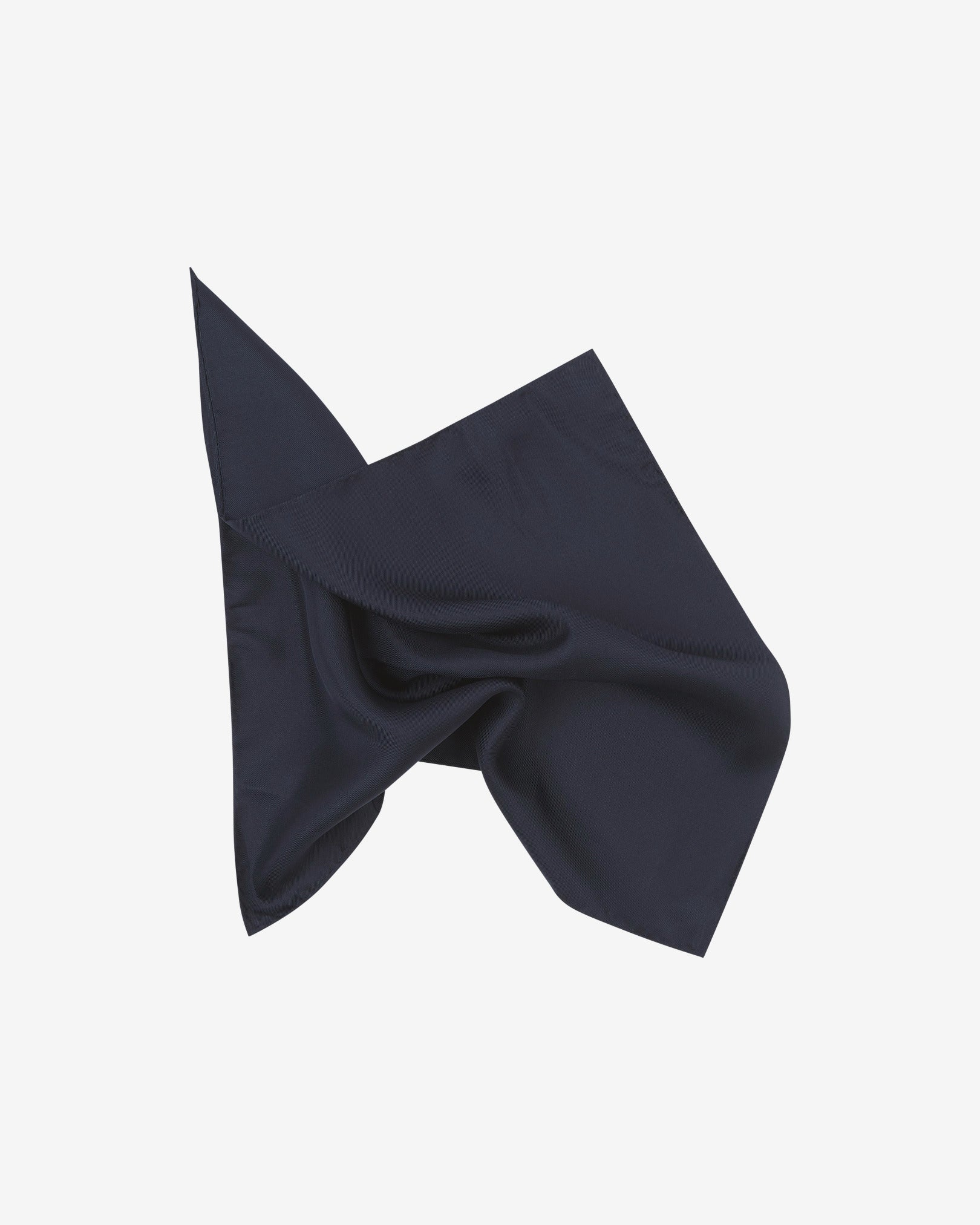 The plain, navy-blue silk pocket square pinched and twisted in the middle, presenting the sheen of the fine silk material.