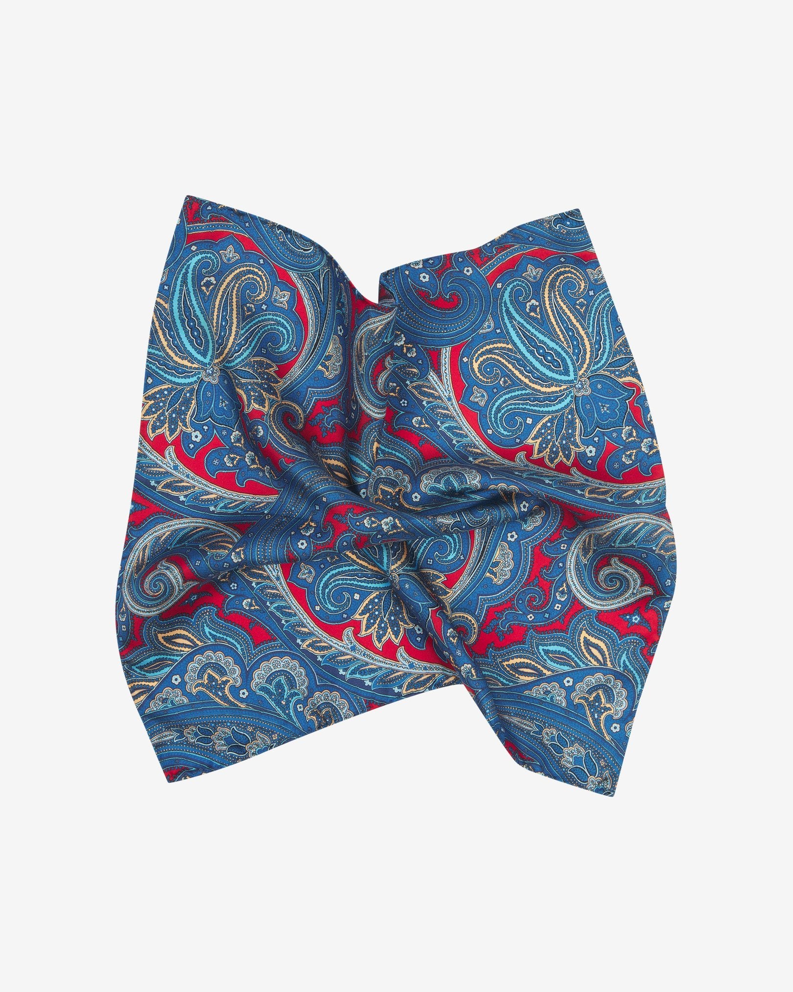 The 'Oxford' silk pocket square pinched and twisted in the middle, presenting a closer view of the large and smaller paisley pattern on a deep red ground.