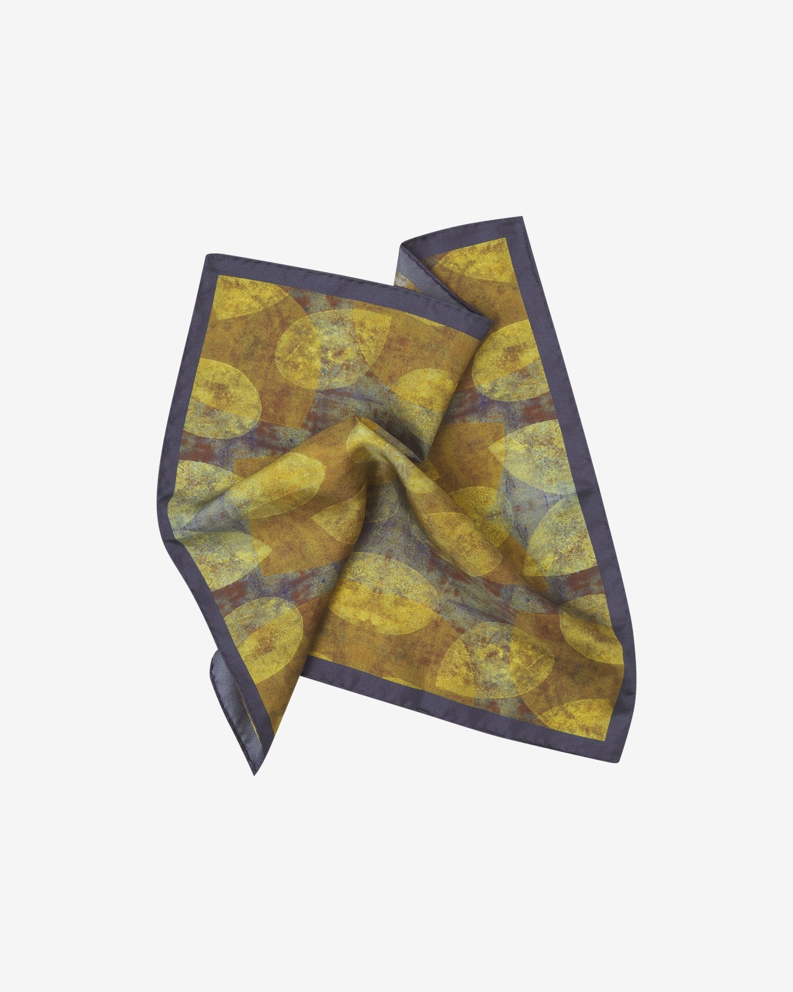 The 'Tweed' silk pocket square pinched and twisted in the middle, showing the stylised leaf forms creating a yellow and purple textured effect.