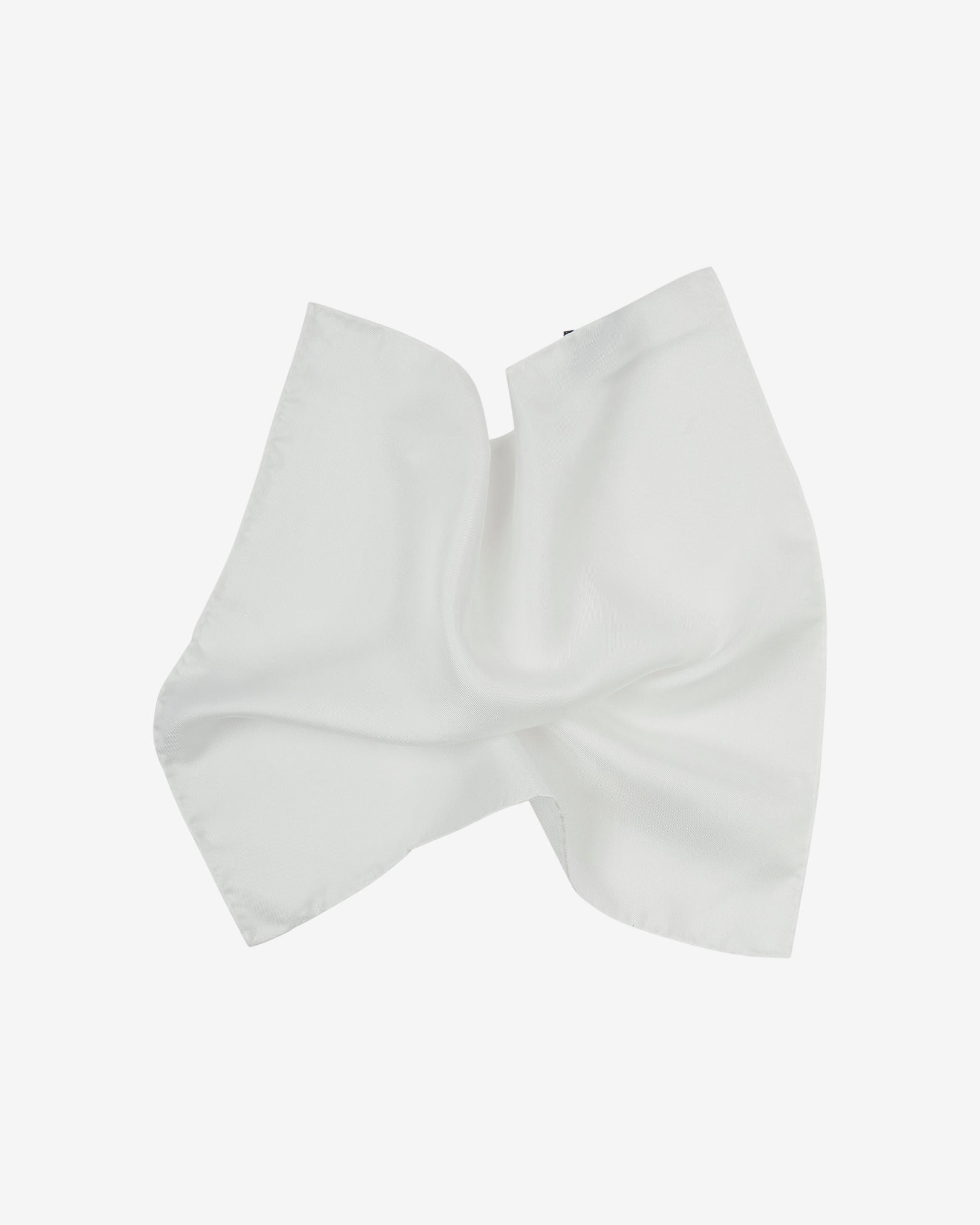 The plain, white silk pocket square pinched and twisted in the middle, presenting the sheen of the fine silk material.