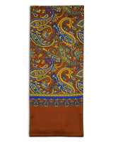 A flat view of 'The Whistler' multicoloured paisley polyester scarf on a rich, brown background. Clearly showing the blue, yellow, gold and green paisley patterns.
