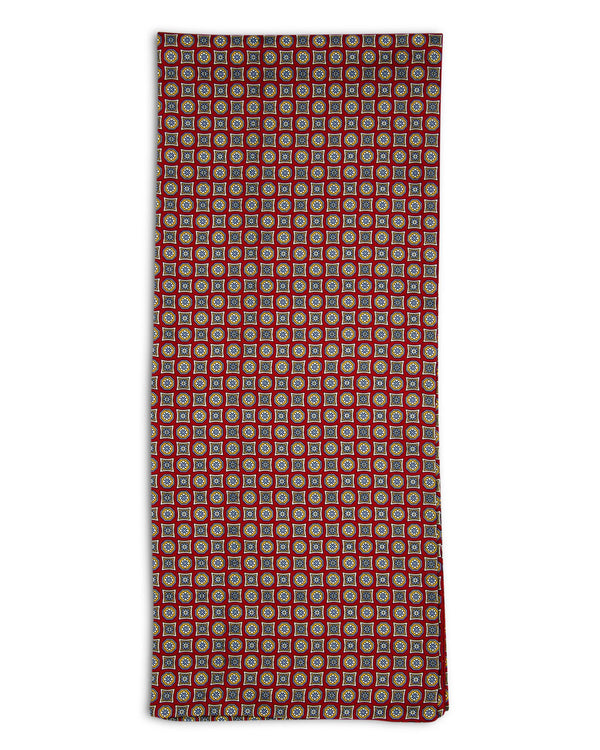 A flat view of 'The Morne' pure silk, mosaic scarf. Clearly showing the intricate circle and square patterns on a rich red ground.