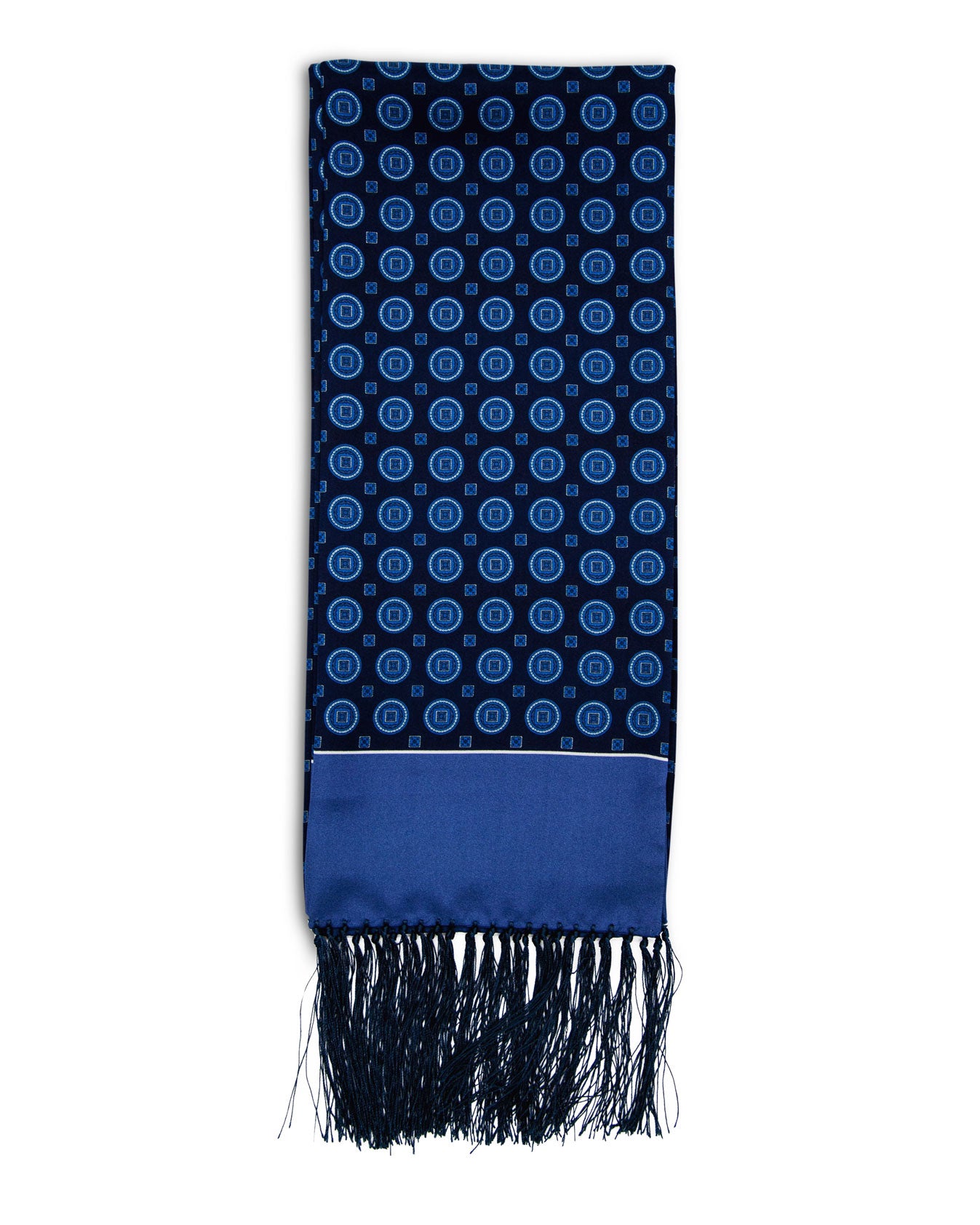 A flat view of 'The Palm' blue silk aviator scarf. Clearly showing the light blue circle patterns on a navy-blue ground with matching light blue end border and dark 3-inch fringe.