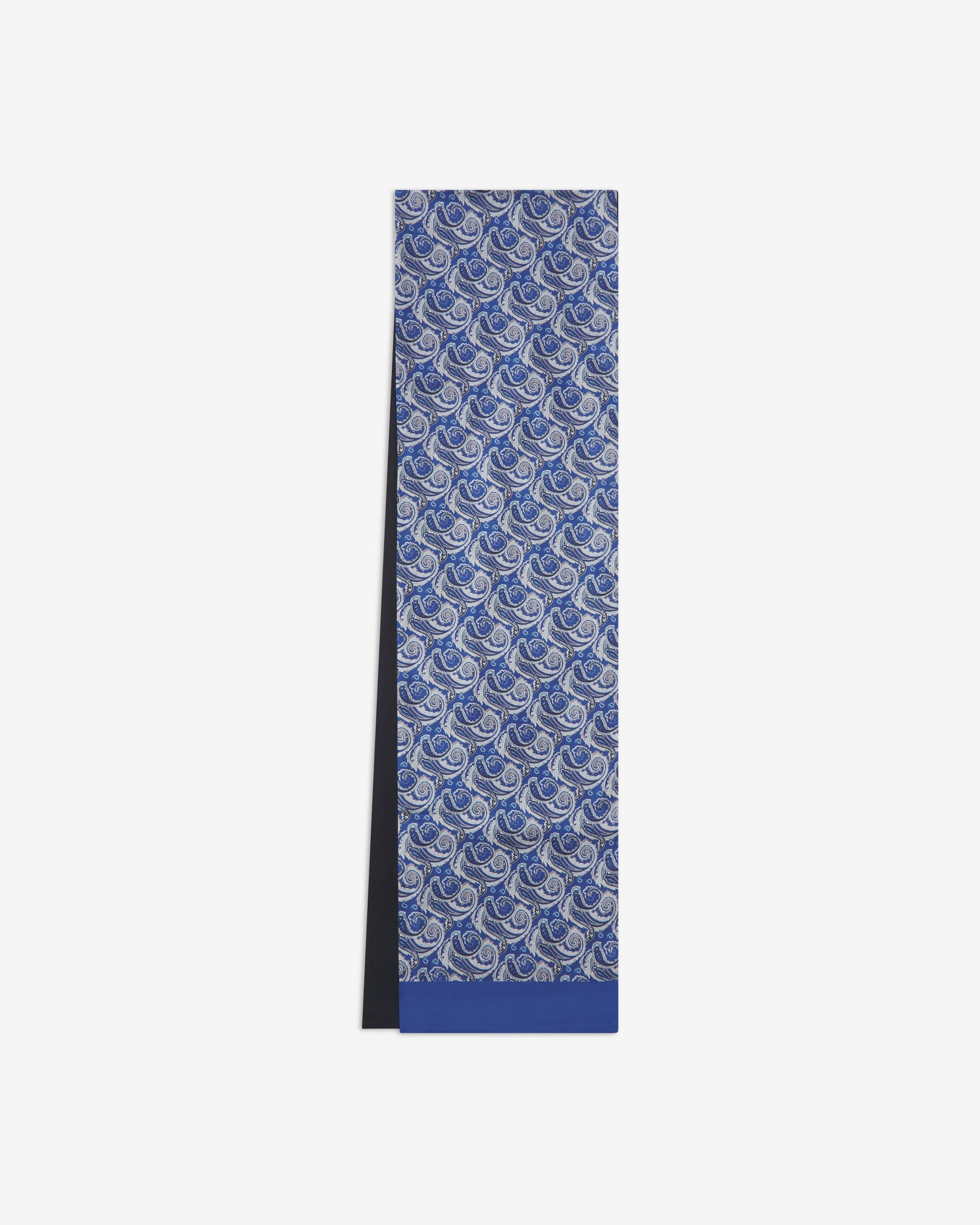 The Renton dress scarf arranged in a rectangular shape with a focus on the intricate silver, black and light blue paisley swirls on the silk side of the fabric.