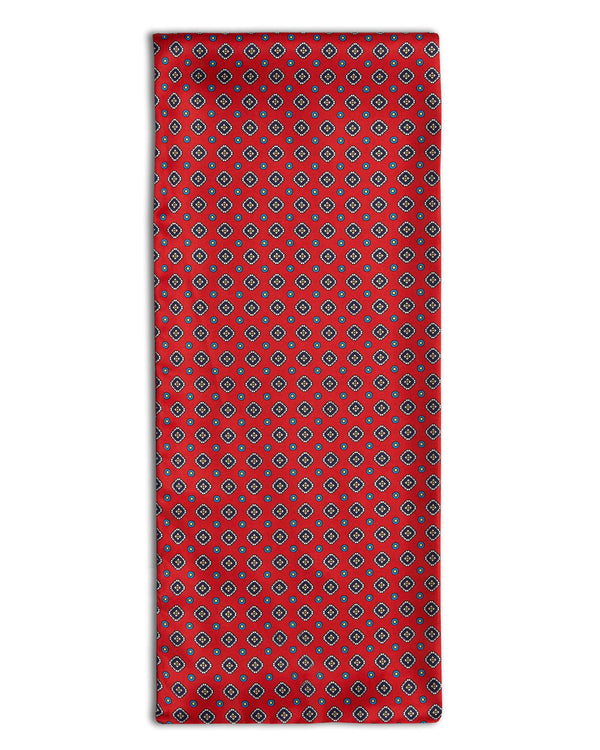 'The Romilly' geometric red polyester scarf arranged in a rectangular shape, clearly showing the multi-coloured patterns.