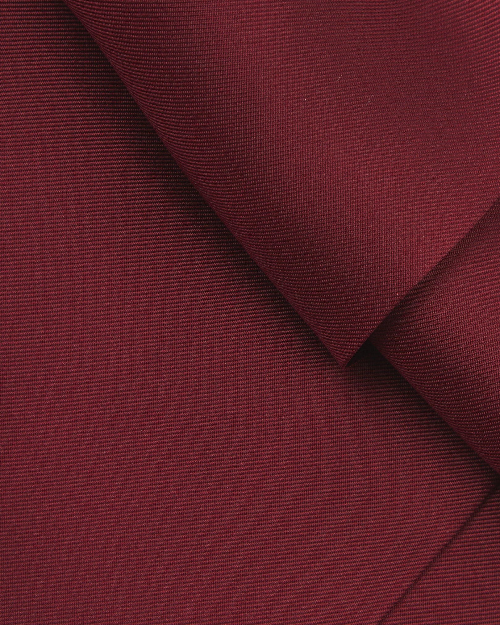 A ruffled close-up of the wine-red double Ascot from Soho Scarves, presenting a closer view of the silk fabric and sheen.