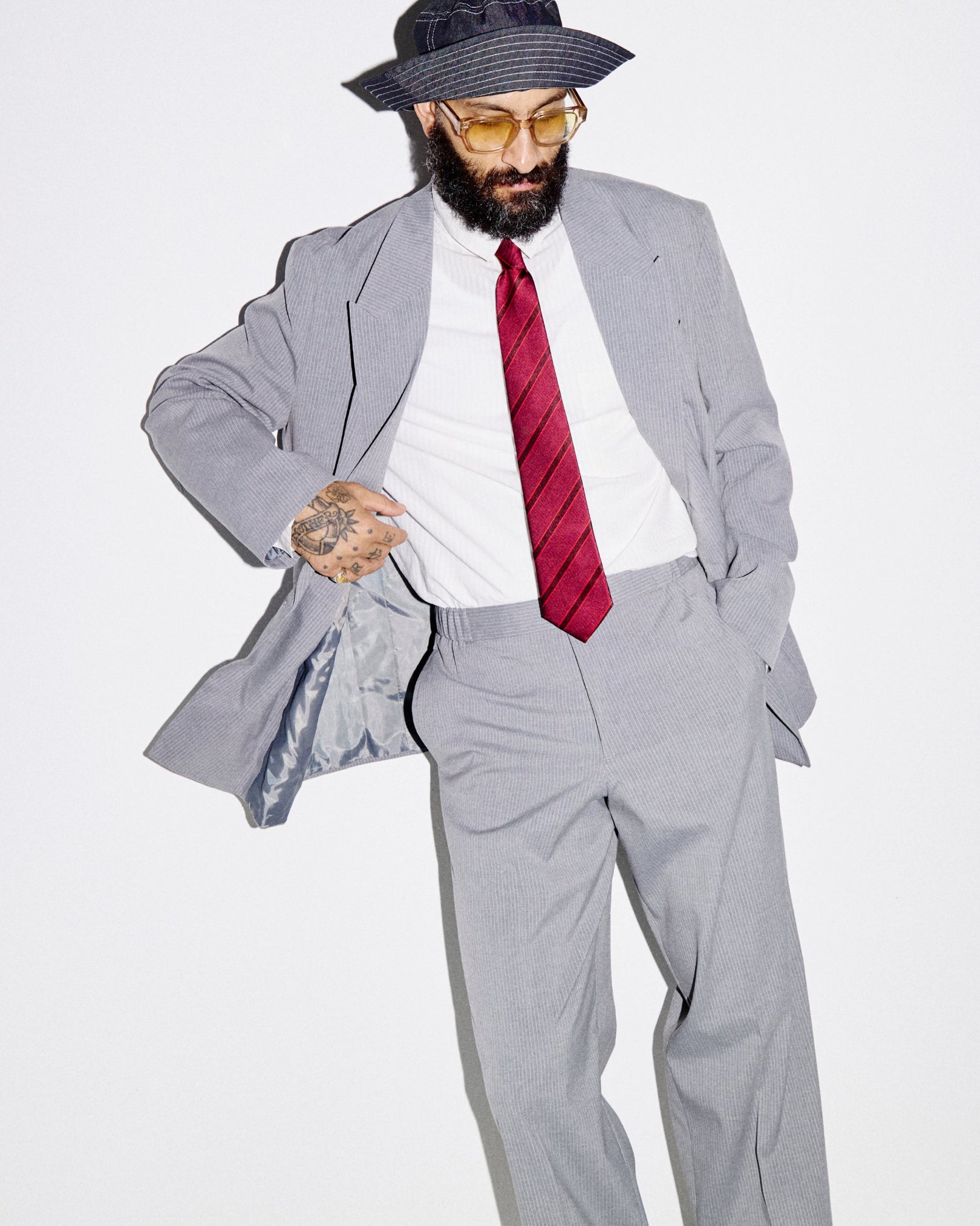 Man wearing the 'Sanders Good Fortune' silk neck tie with clear view of diagonal red stripes. Paired with light grey suit.