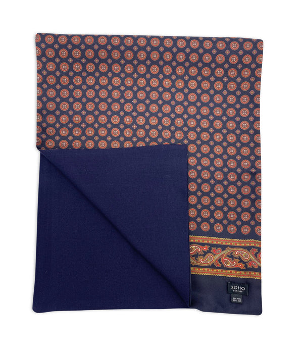 The wide version of 'The Luke' wool-lined silk dress scarf. Arranged in a square shape with a corner folded back to reveal the fine navy woollen underside.