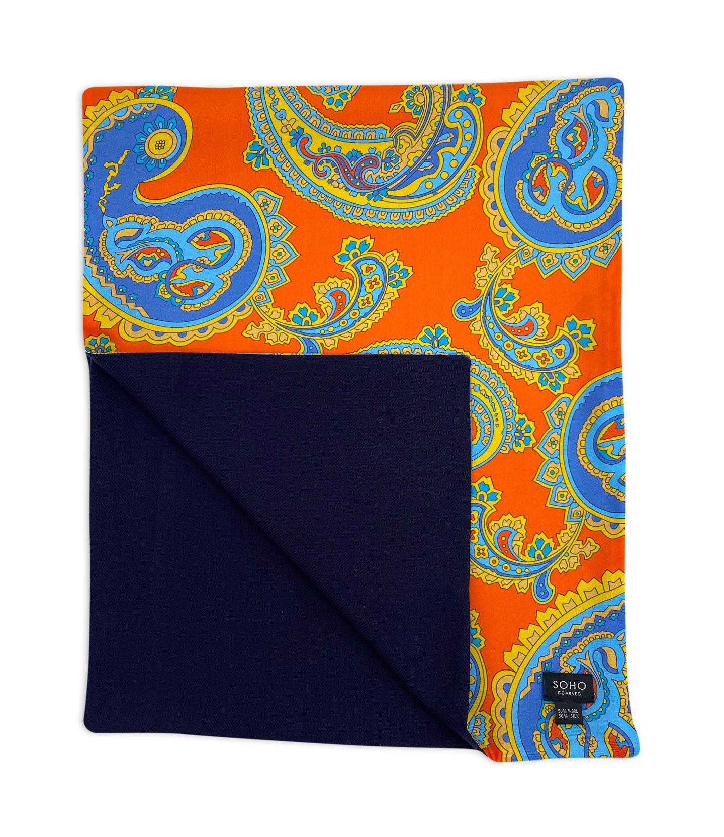 The wide version of 'The Orange' multicoloured paisley wool-lined silk dress scarf on a deep orange background. Arranged in a square shape with a corner folded back to reveal the fine navy woollen underside.