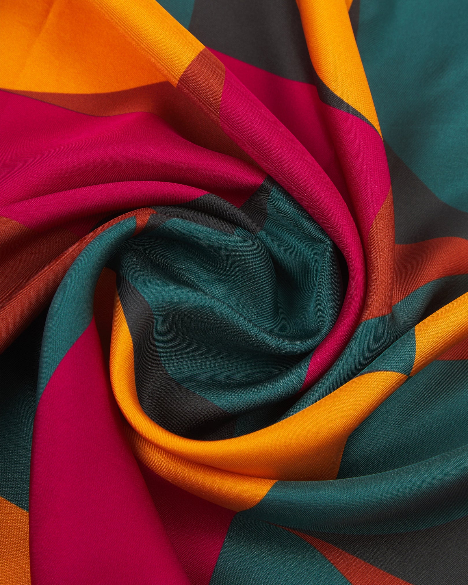 A ruffled close-up of the 'Stuttgart' silk scarf, presenting a closer view of the multicoloured, Bauhaus inspired patterns.