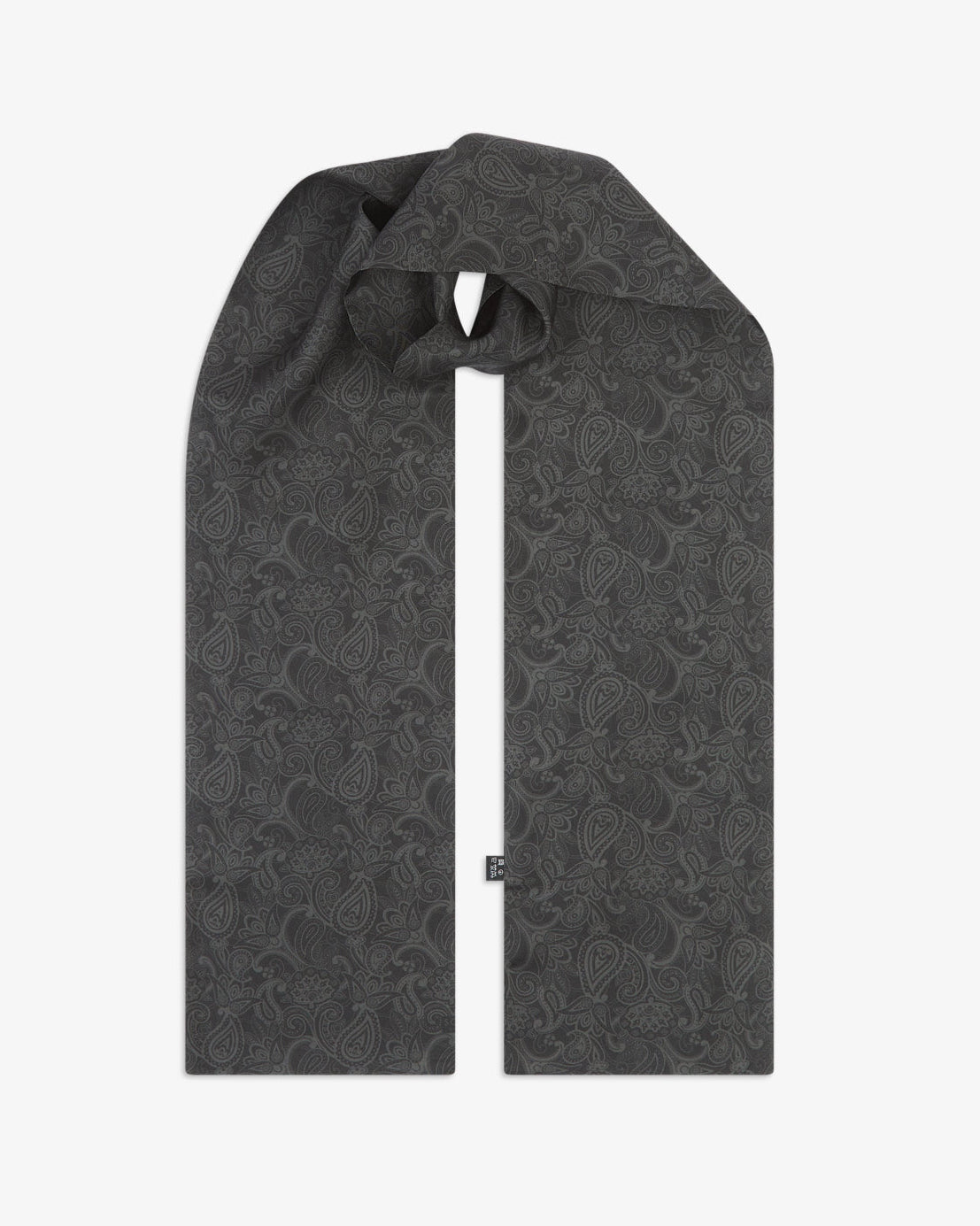 The 'Tonal Paisley' black silk scarf looped with both ends parallel to showcase the full repeat pattern of charcoal paisley motifs on a matte black background.