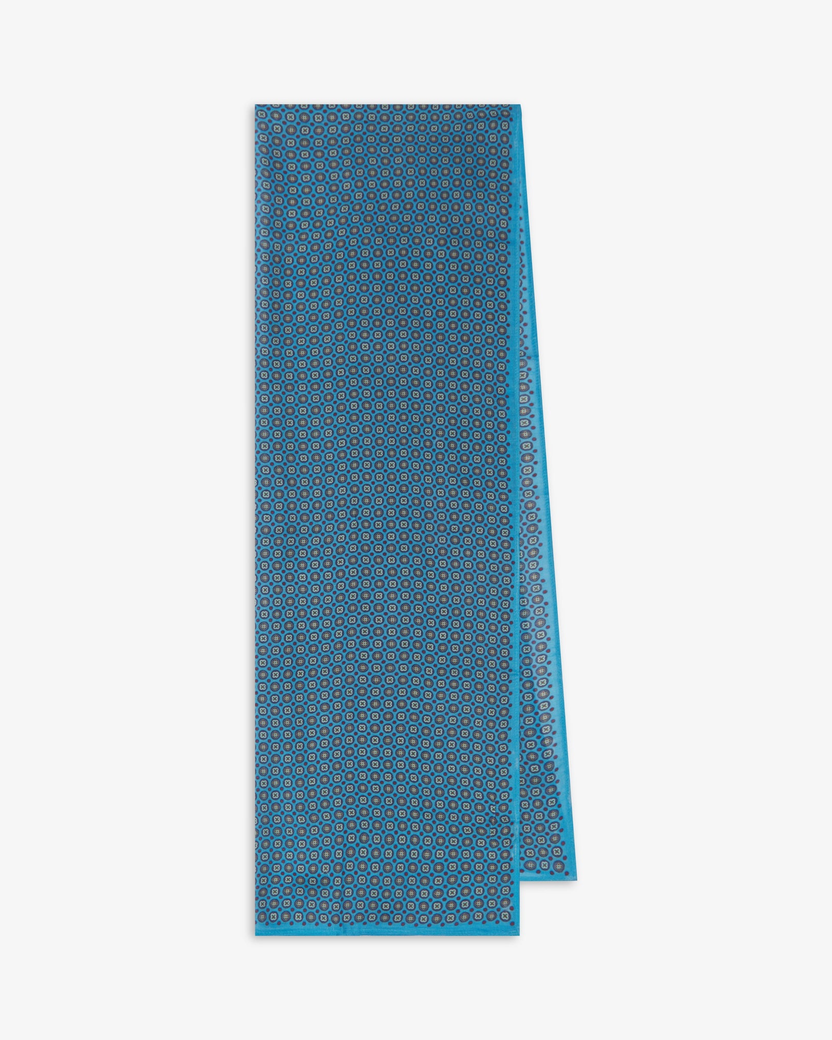 The Toshima 'Gardenia' bohemian wide scarf folded and presented vertically to show the full dimensions and repeating stylised floral pattern in blue, purple, mint green and red on a light blue background.