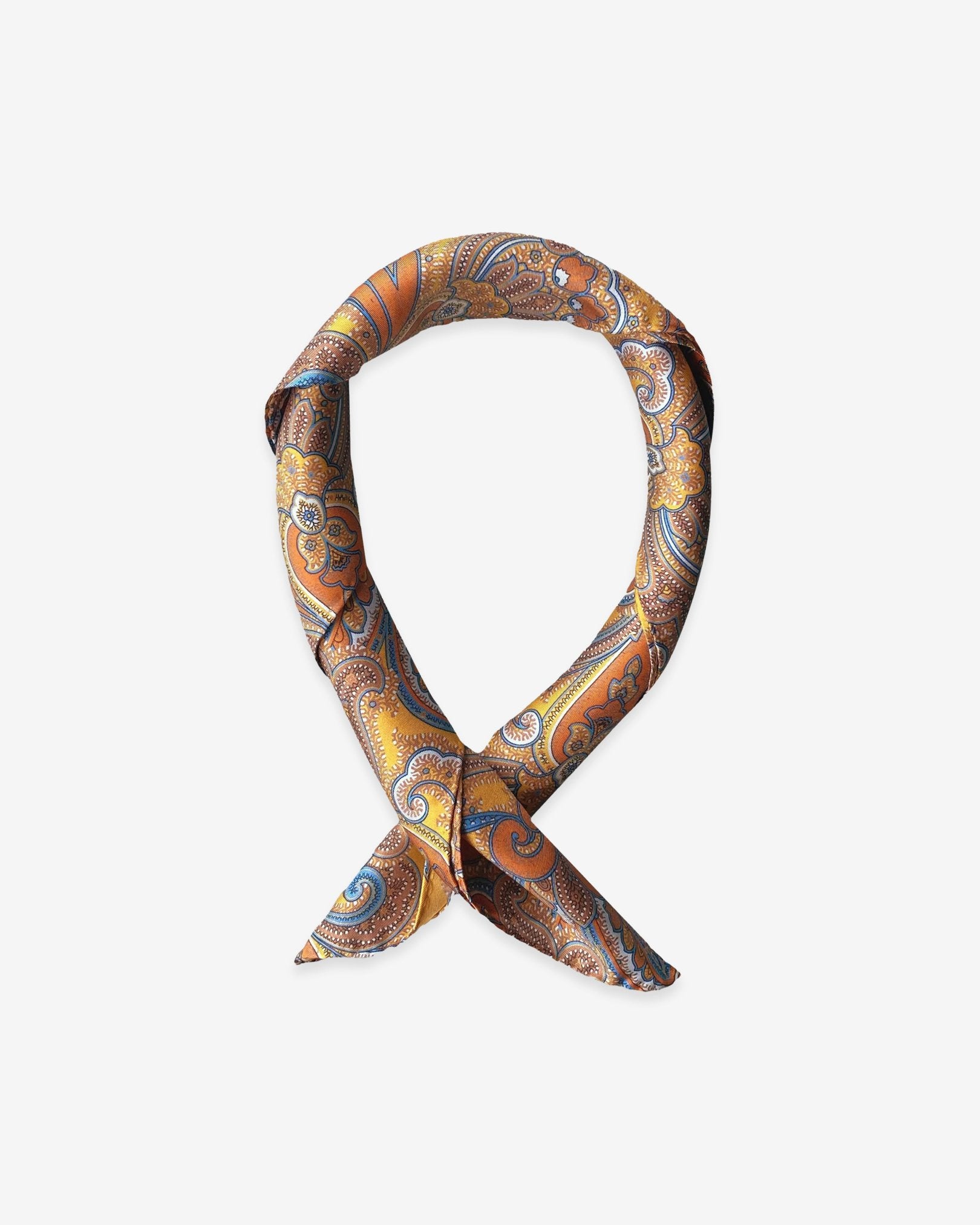 Square scarf rolled into a loop, showing the sheen of the golden yellow neckerchief fabric with vibrant orange, brown and blue paisley patterns.