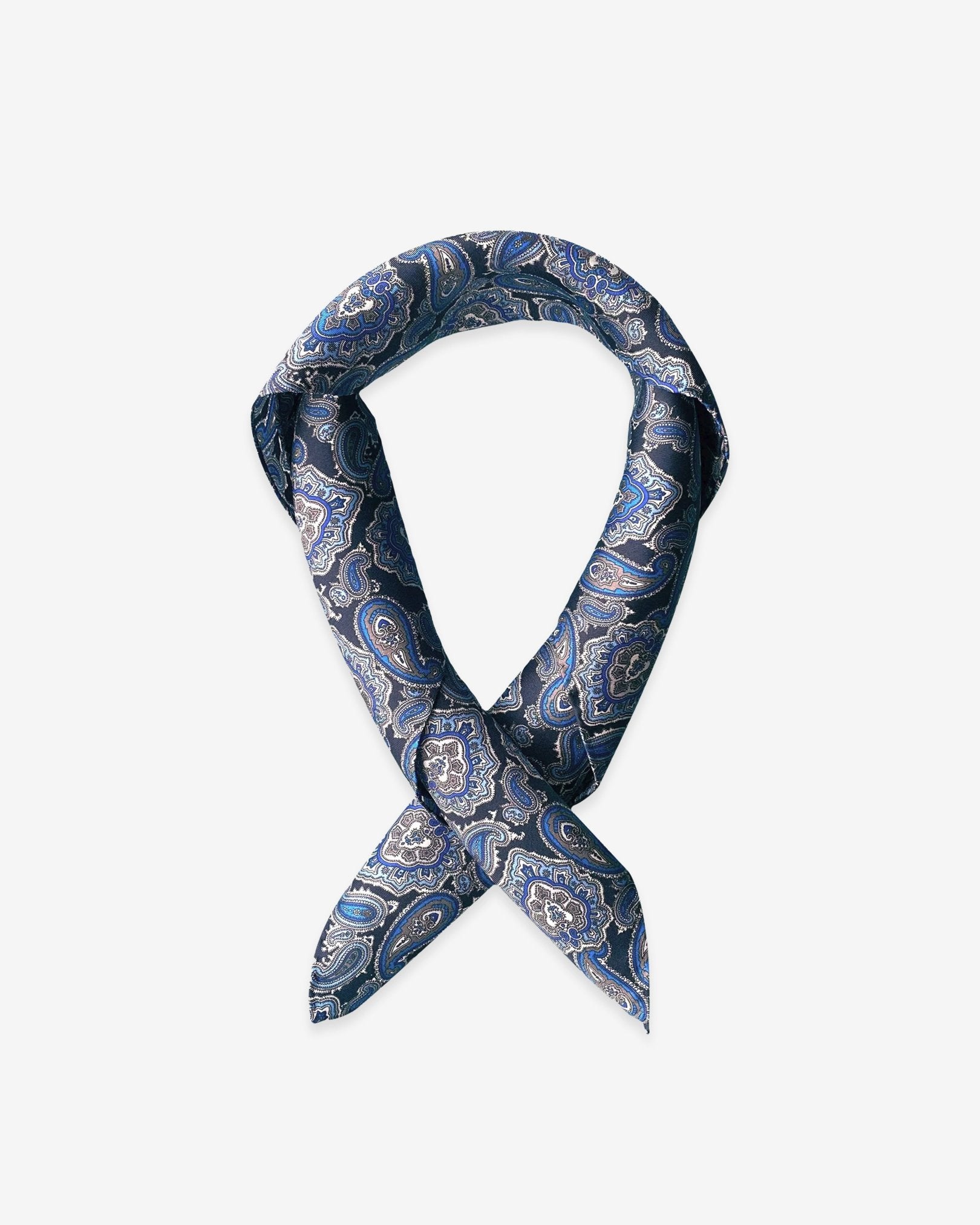 Square scarf rolled into a loop, showing the sheen of the silk neckerchief fabric with blue paisley patterns enhanced with white and grey accents.