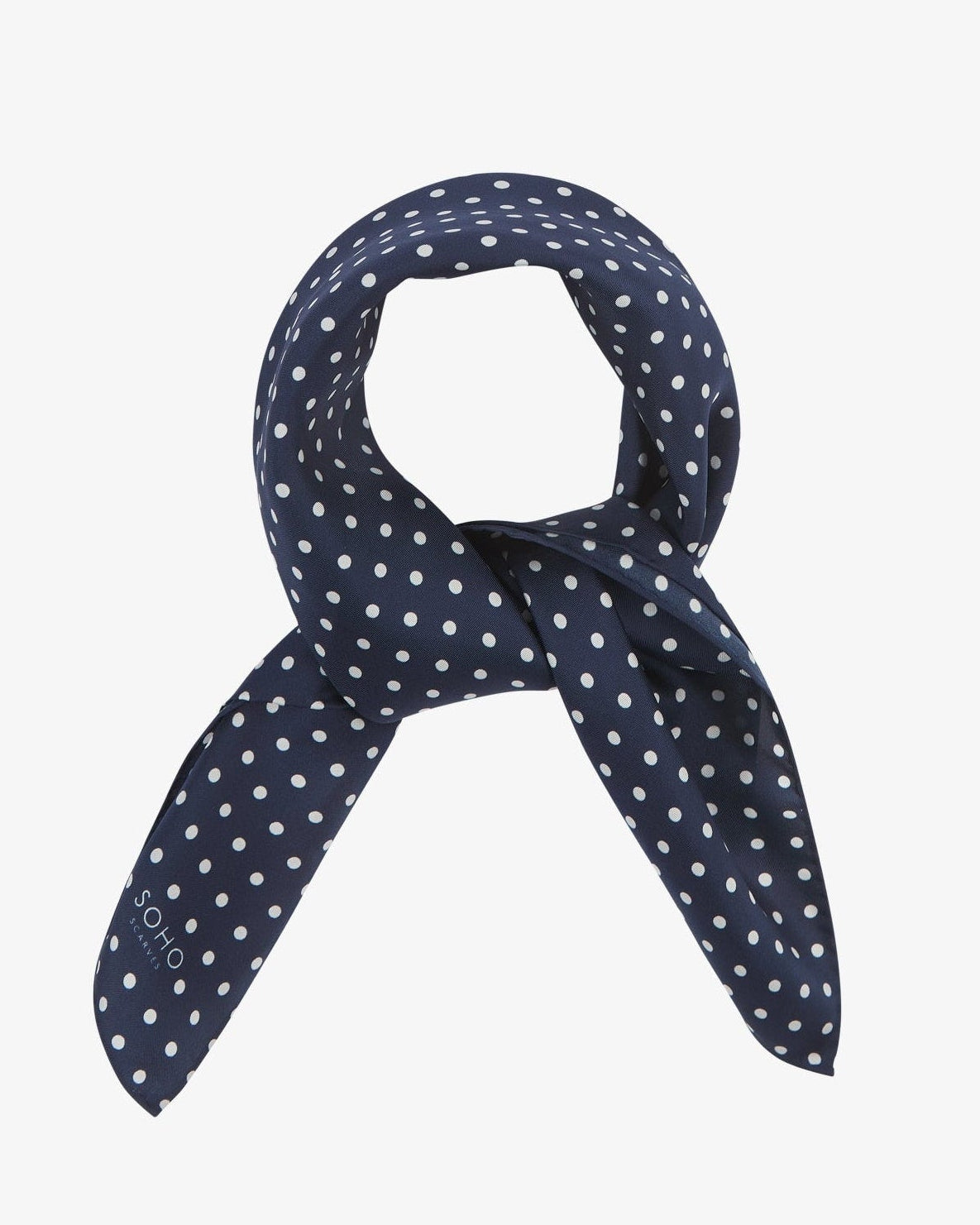 Square scarf rolled into a loop, showing the fabric sheen of the classic dark-blue and white spotty silk fabric