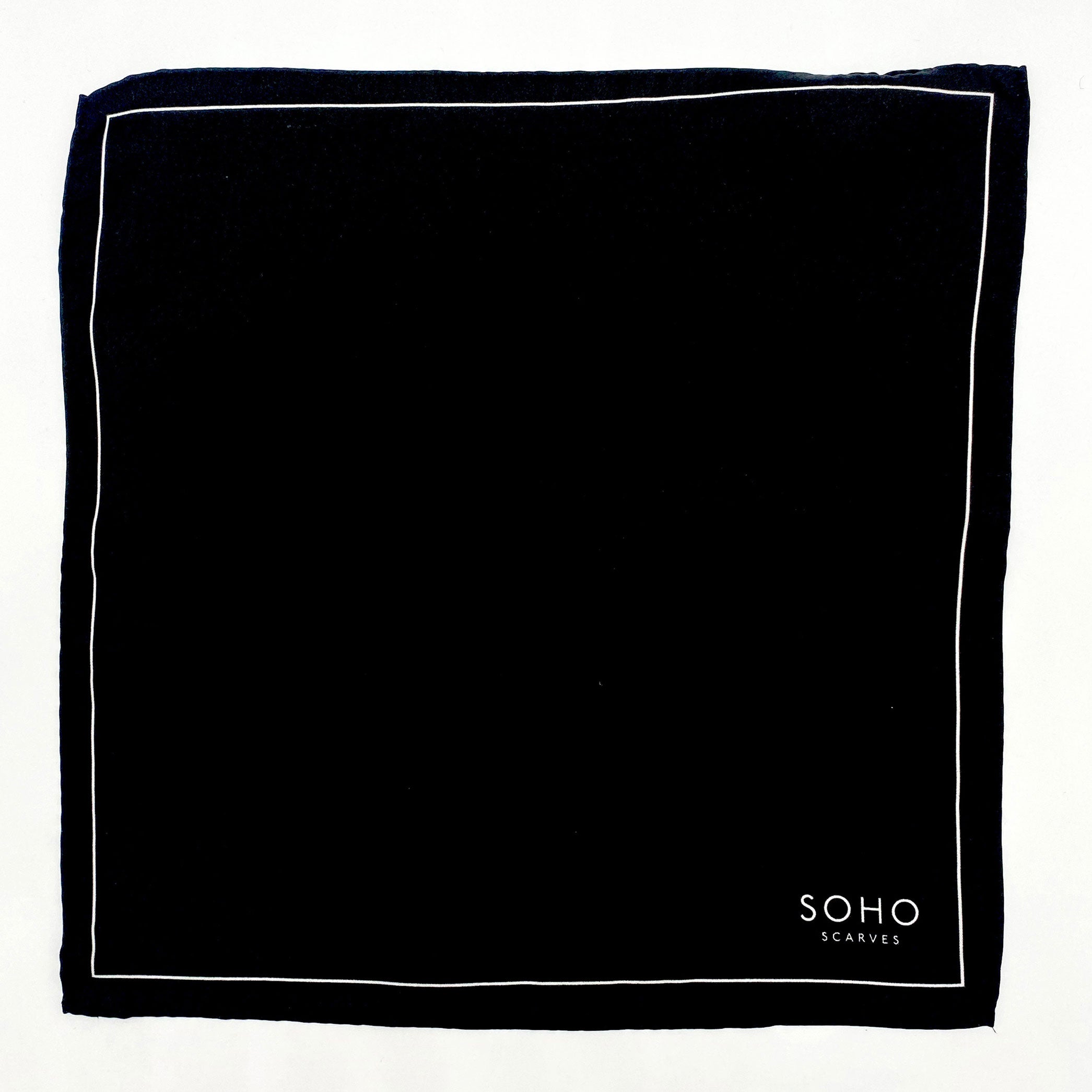Completely unfolded black silk pocket square showing the entirity of the thin white border and the branding logo to the bottom-right.