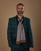 Front view wearing a 'The Bellingham' floral geometric silk scarf from SOHO Scarves, paired with a black shirt and deep green chequered suit.