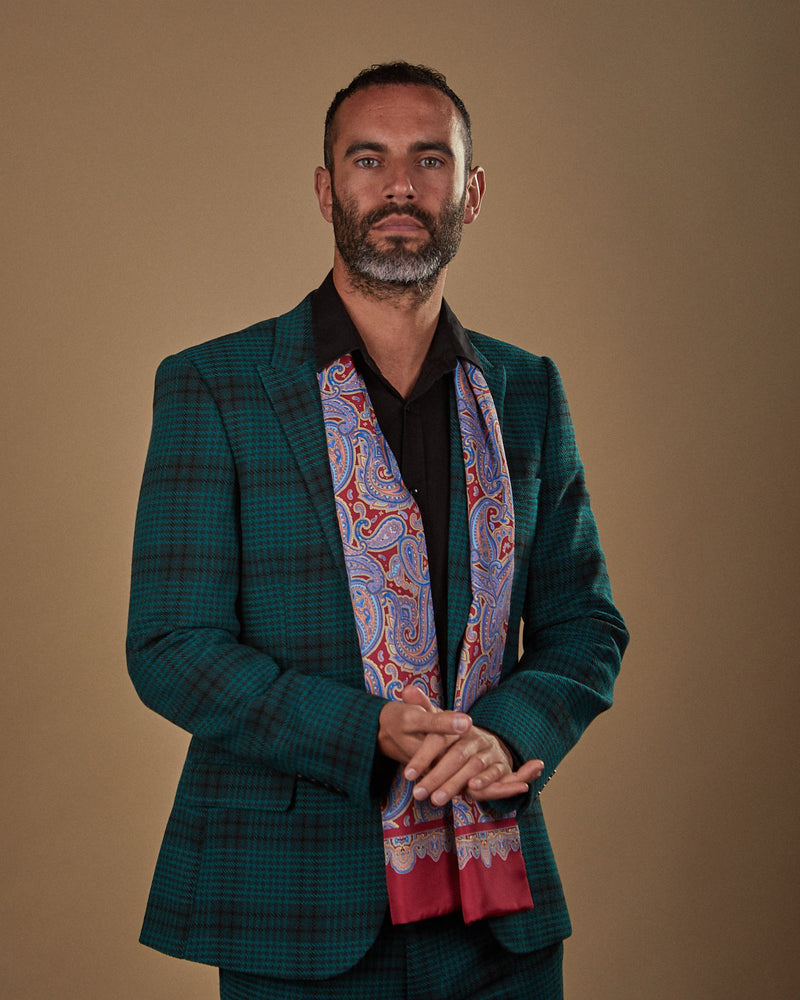 Front view wearing a 'Hedge' paisley polyester scarf from SOHO Scarves, paired with a black shirt and deep green chequered suit.