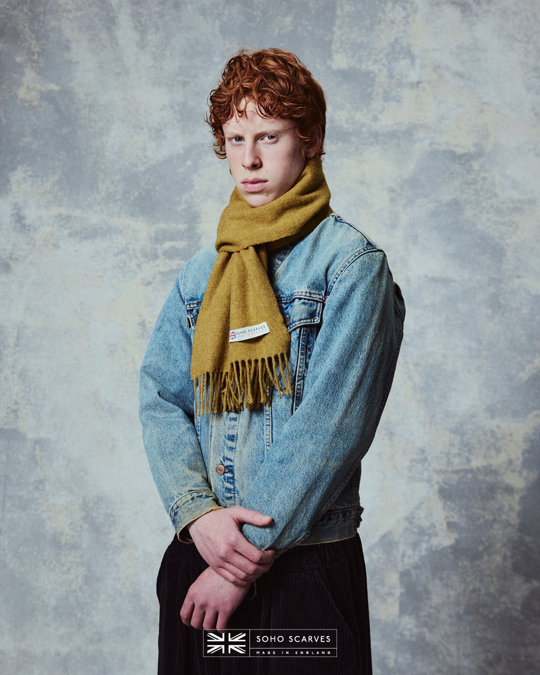 Top-half view of man wearing the Yorkshire-made, 'Lowlands in Gold' wool scarf from Soho Scarves.