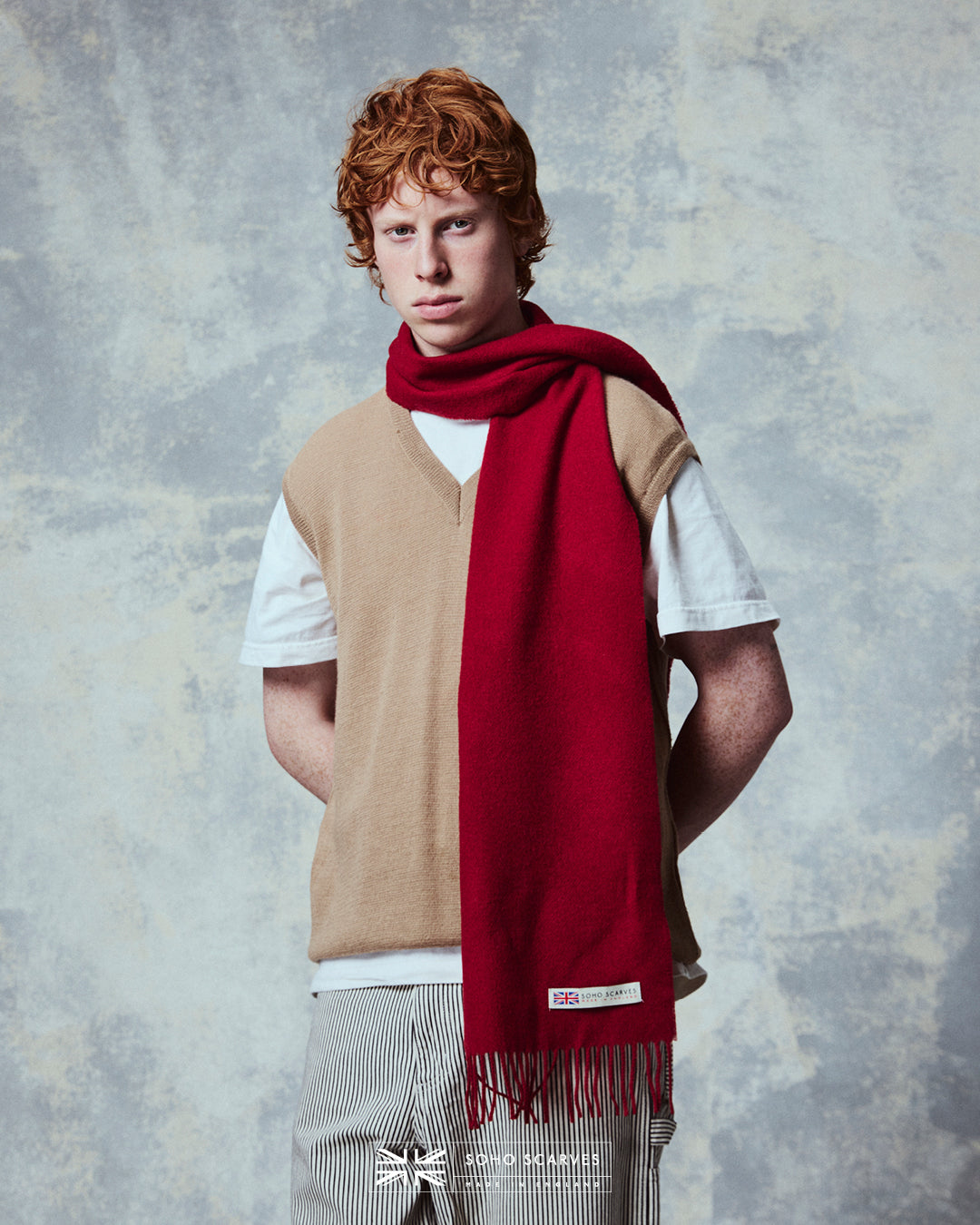 Top-half view of man wearing the Yorkshire-made, 'Lowlands in Scarlet' wool scarf from Soho Scarves.
