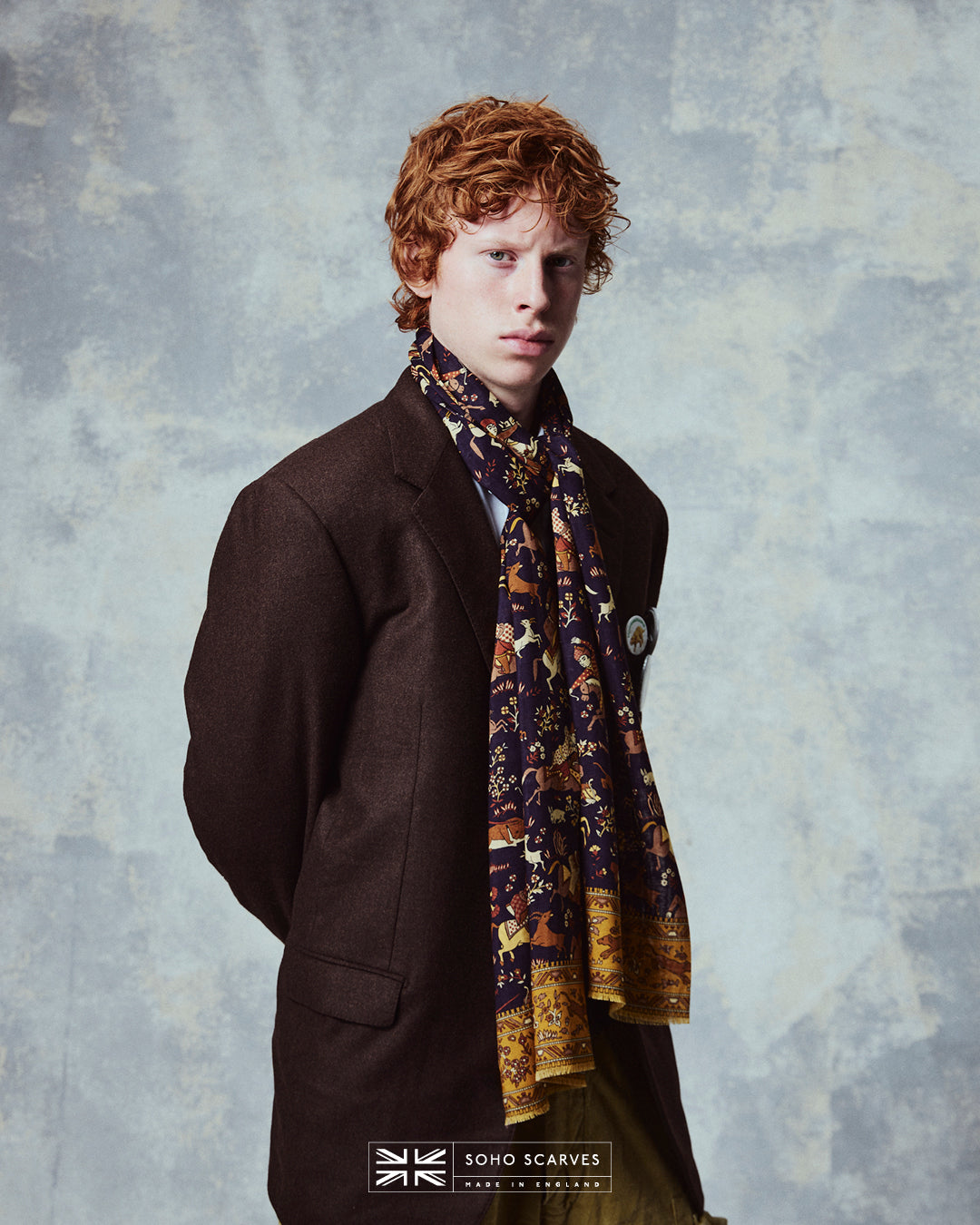 Top-half view of man wearing the English-made, 'Hunters in Indigo' silk and wool scarf from Soho Scarves.