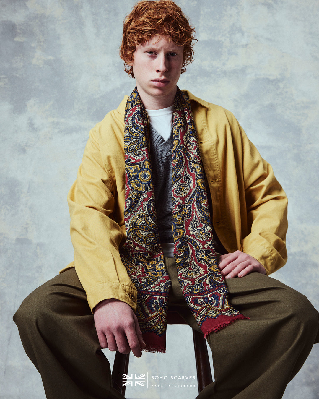 Top-half view of man wearing the English-made, 'Paisley in Red' silk and wool scarf from Soho Scarves.