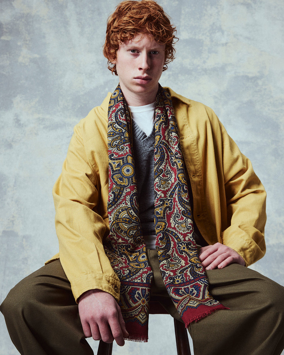 Top-half view of man wearing the English-made, 'Paisley in Red' silk and wool scarf from Soho Scarves.