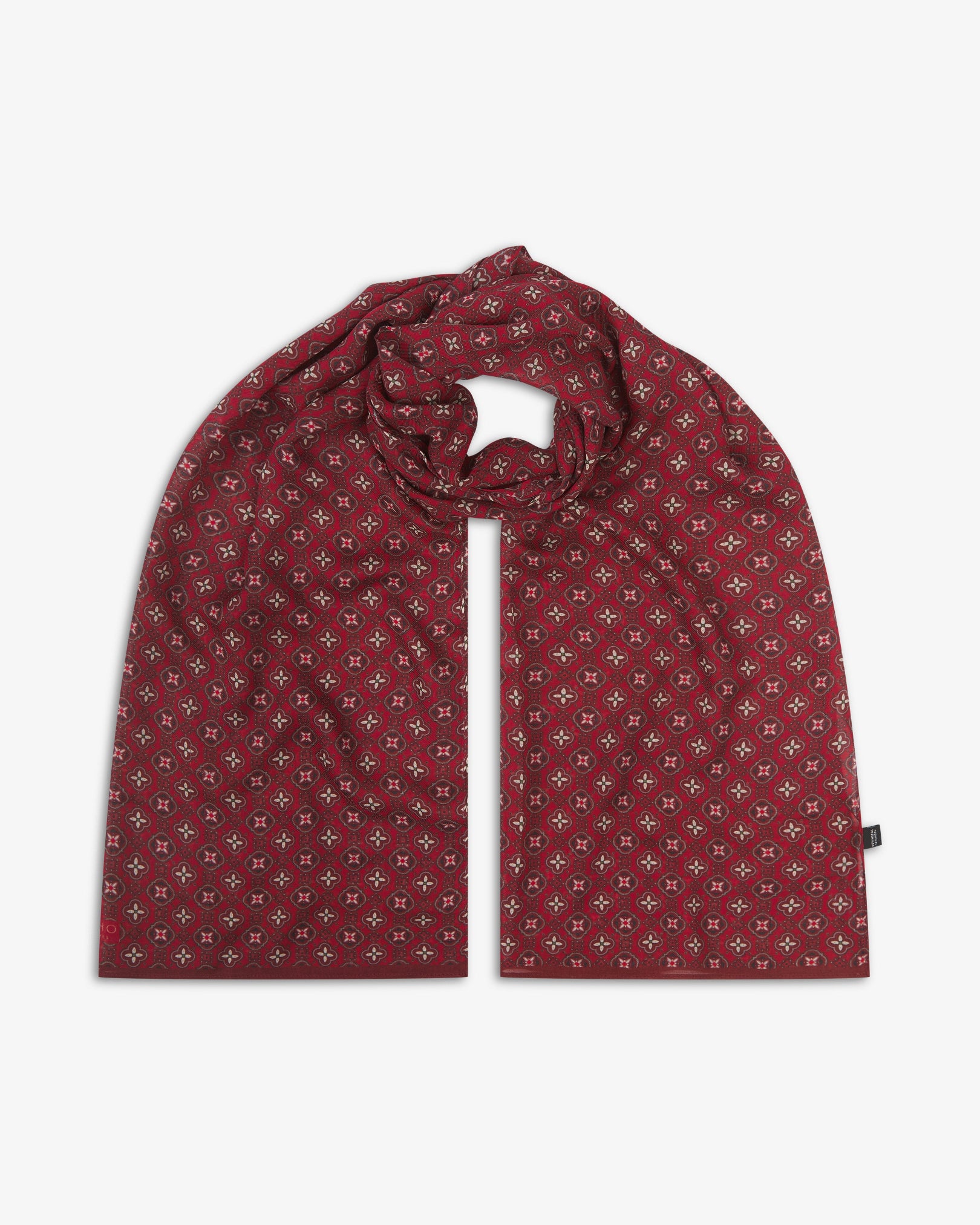 The Wenatchee 'Good Fortune' bohemian wide scarf looped with both ends parallel, showcasing an intricate floral and geometric pattern in varying shades of red with black and cream accents across the soft modal and wool blend fabric.