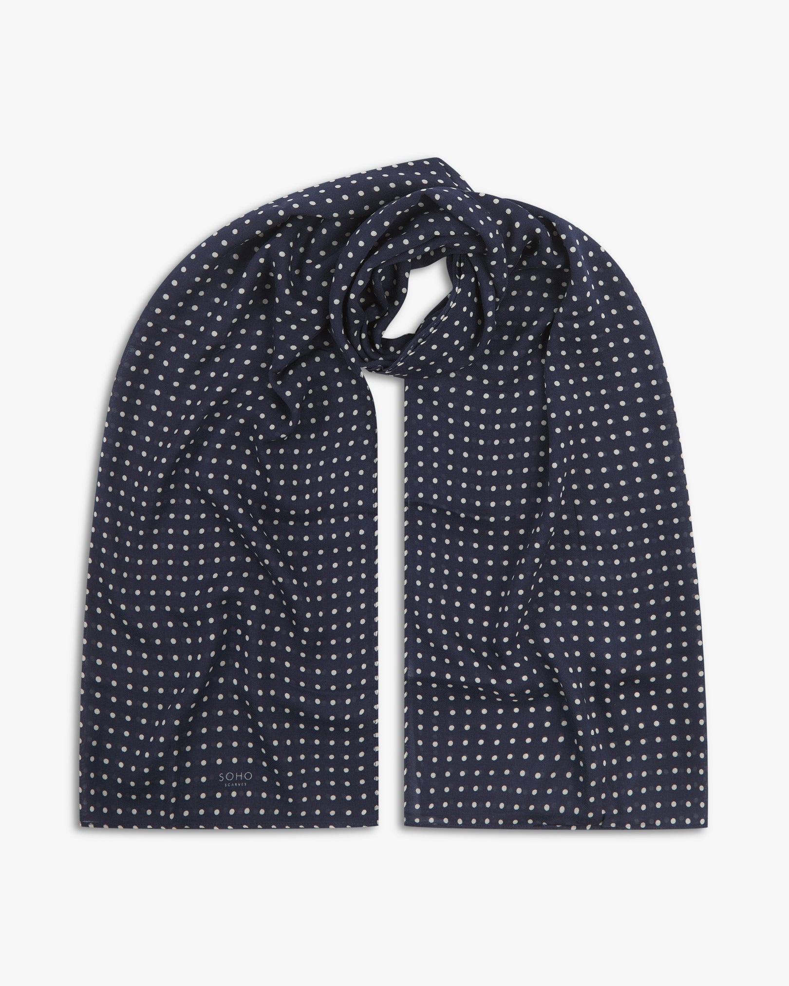 The Westminster bohemian wide scarf looped with both ends parallel, showcasing a classic pattern of white polka dots on a navy blue background across the soft modal and wool blend fabric.