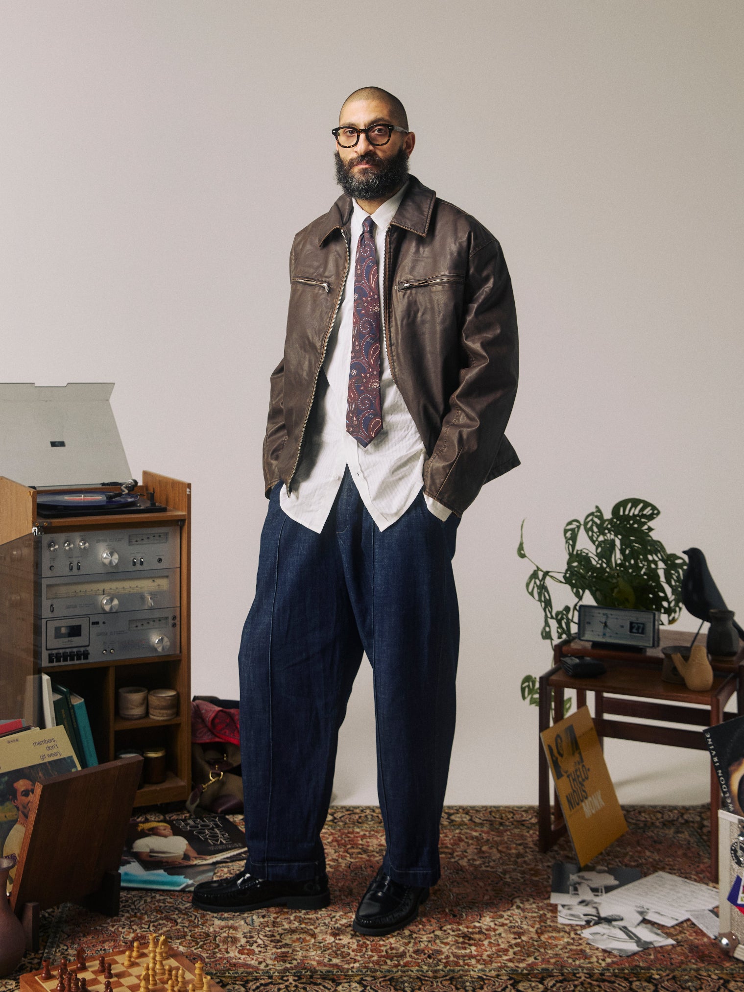 Full-length view of man wearing the 'Windermere Mahogany Haze' paisley silk neck tie in navy and brown.