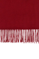 Perfectly horizontal view of the fringe of a red-maroon pure cashmere scarf from Soho Scarves against a white background.